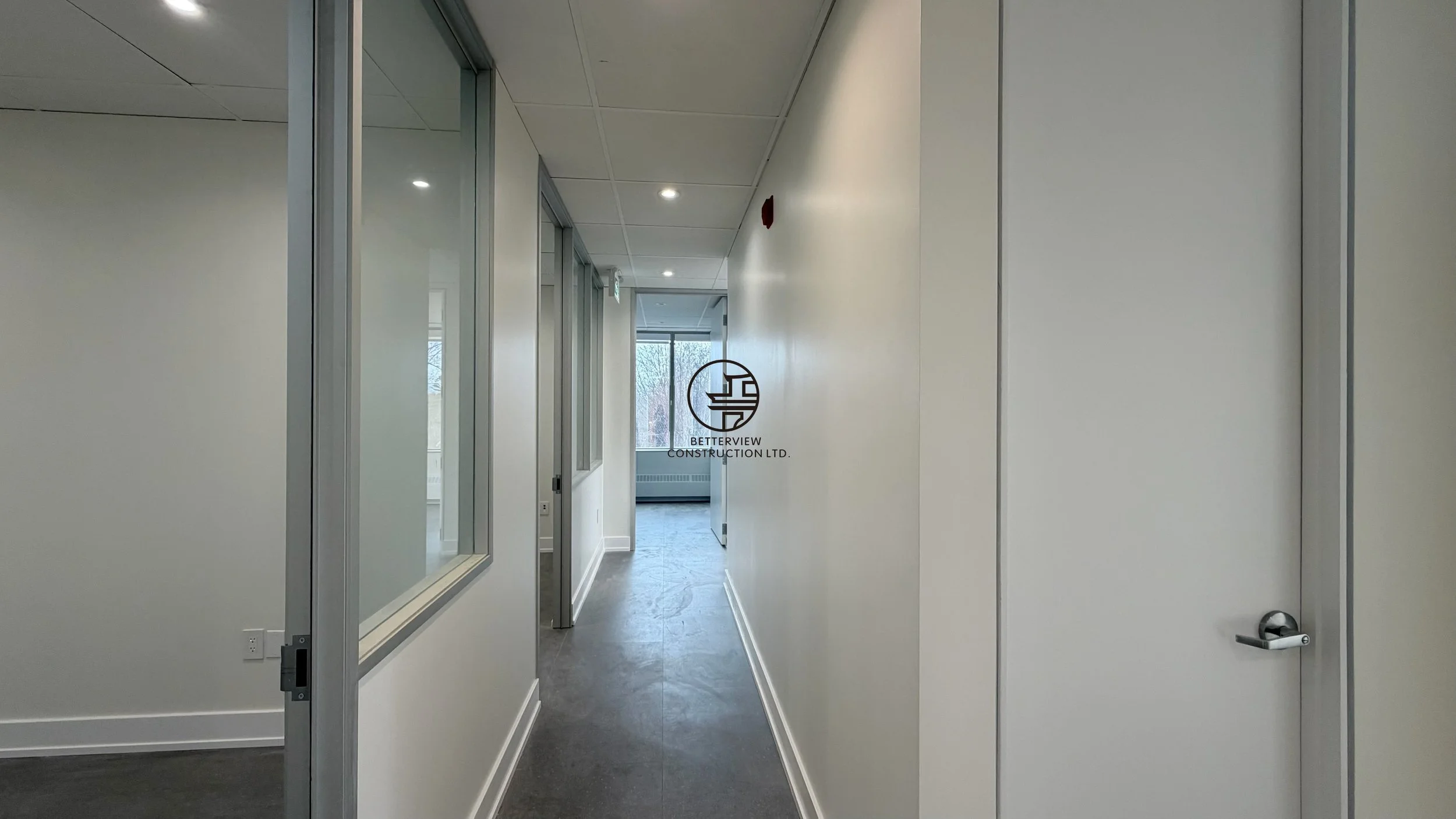 Modern commercial office hallway renovation with clean white walls, glass partitions, and polished flooring in a GTA workspace