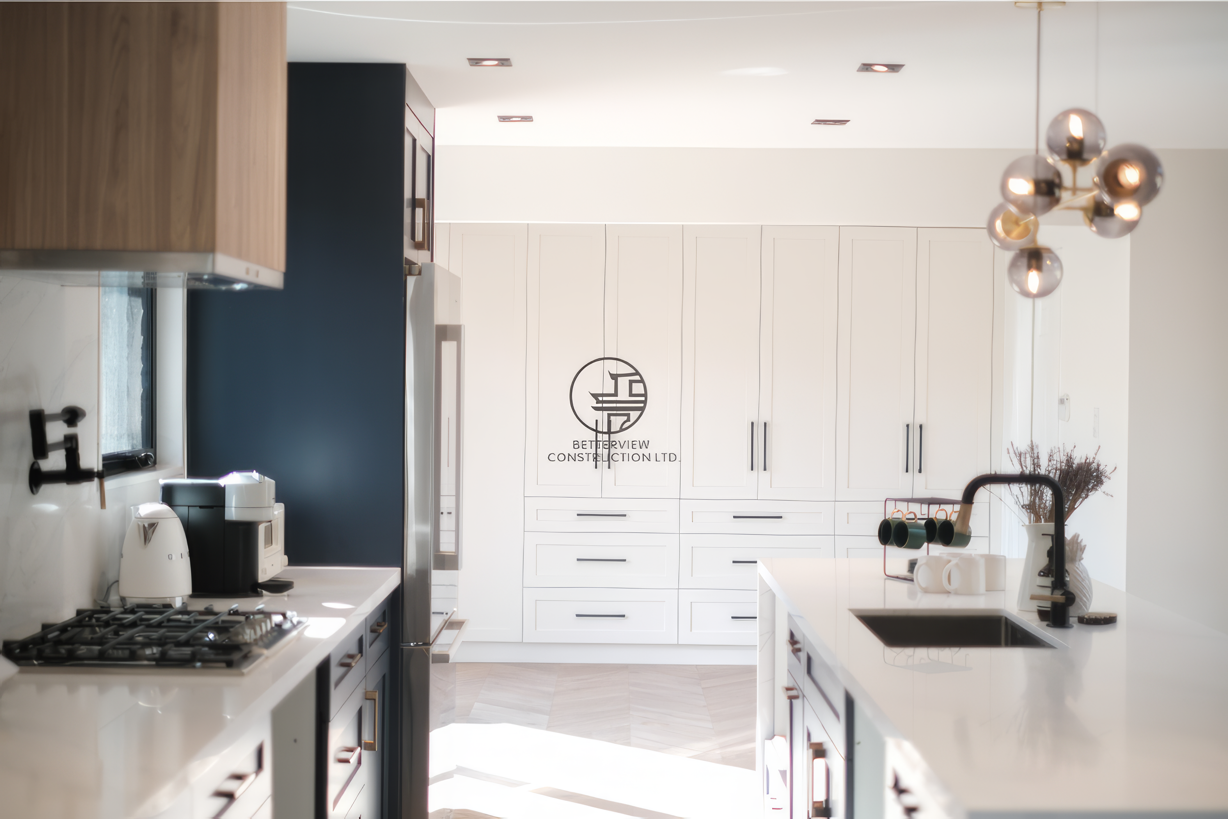 Modern kitchen renovation with white cabinetry, large island sink, and contemporary pendant lighting in a Toronto home.