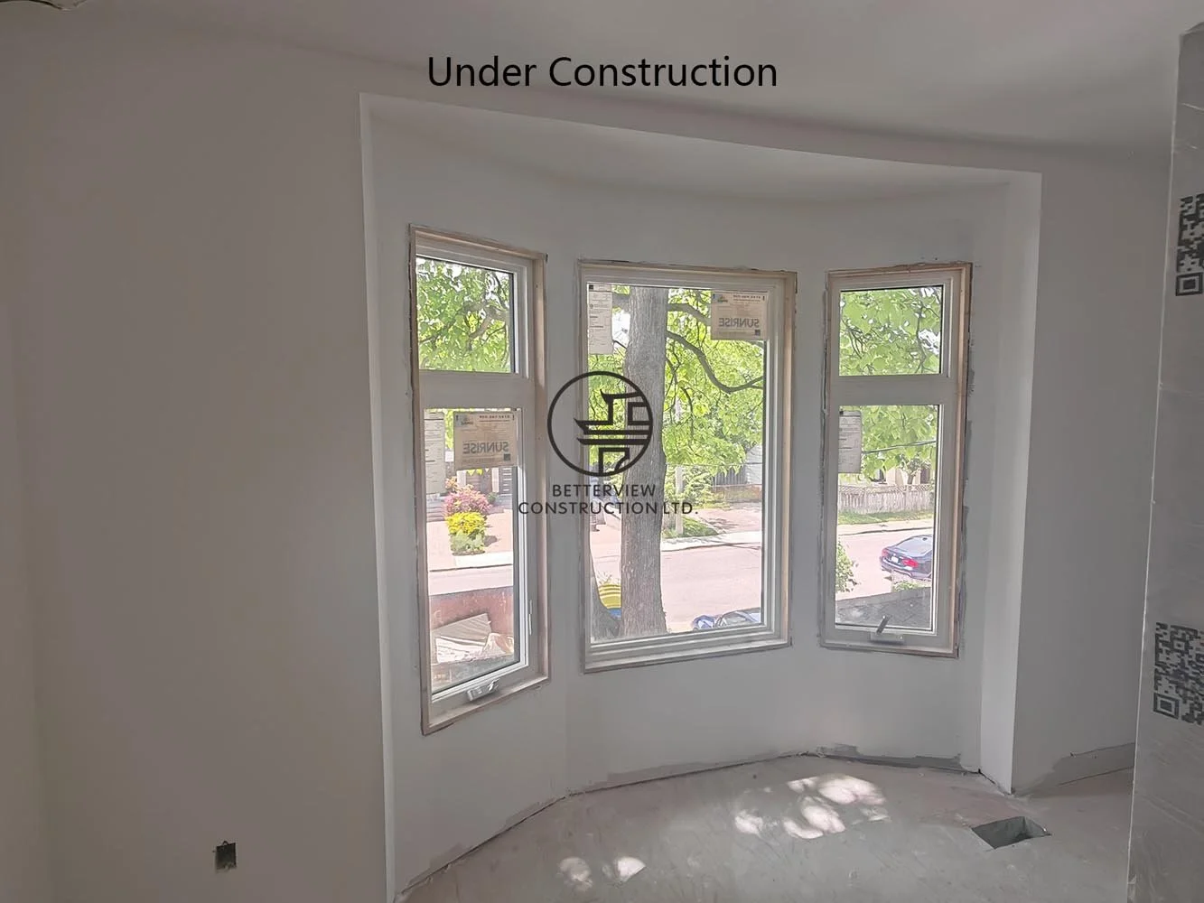 Bright bedroom featuring a bay window, smooth drywall, and abundant natural light before the final finishing stage.