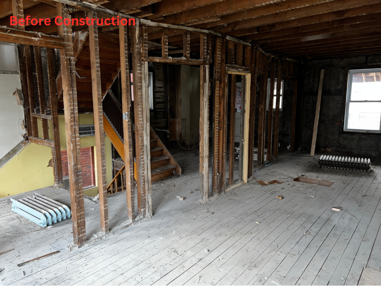 Before construction interior with exposed studs, open layout, visible staircase, and unfinished flooring during a full home renovation project