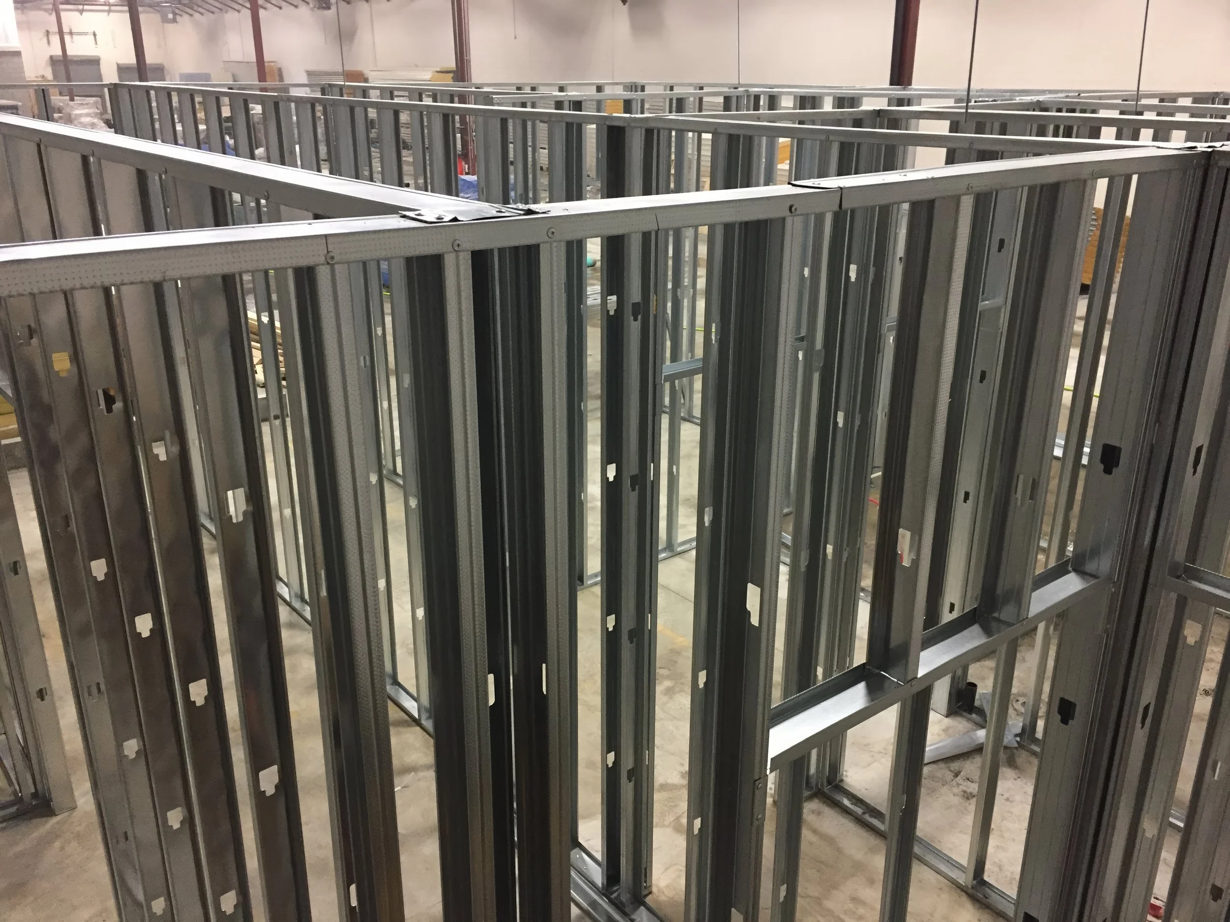 Commercial interior renovation showing steel stud framing for partition walls inside a warehouse construction project in Toronto