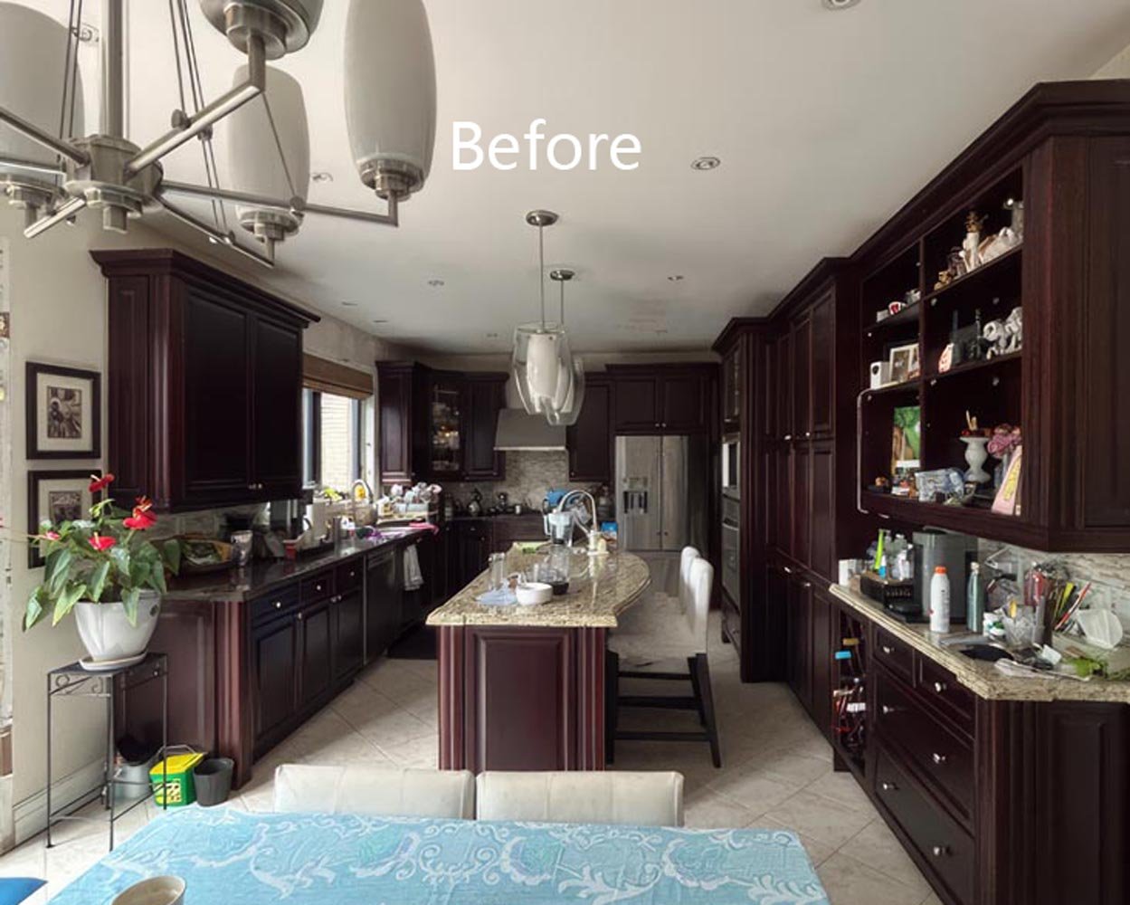 traditional kitchen before renovation with dark wood cabinets center island pendant lighting and cluttered countertops in Toronto home