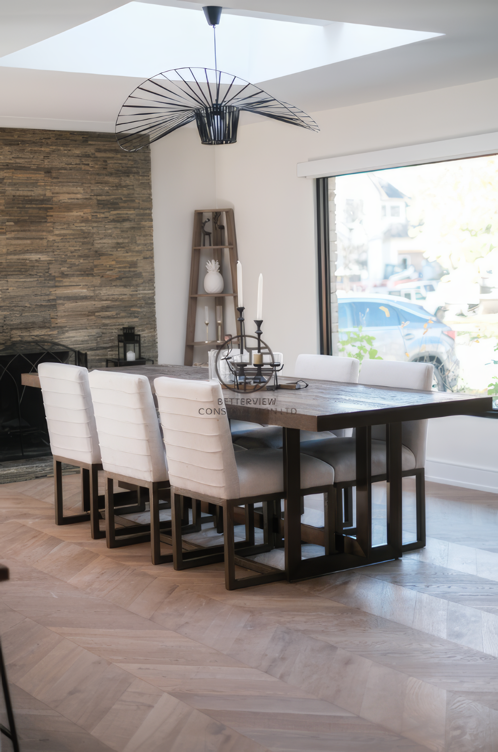 Modern dining room renovation with skylight ceiling, wood dining table, and large window in a Toronto home.