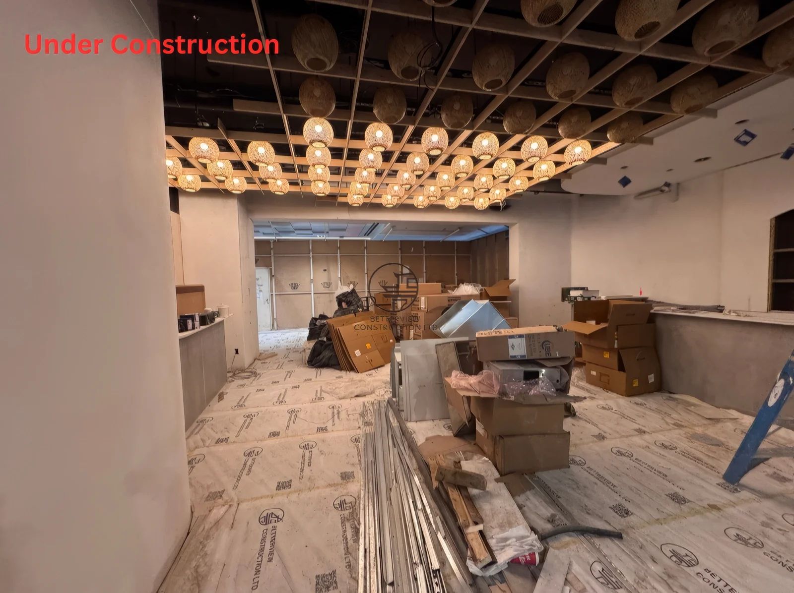 Restaurant renovation in Toronto showing custom ceiling lighting installation with grid structure and ongoing commercial construction