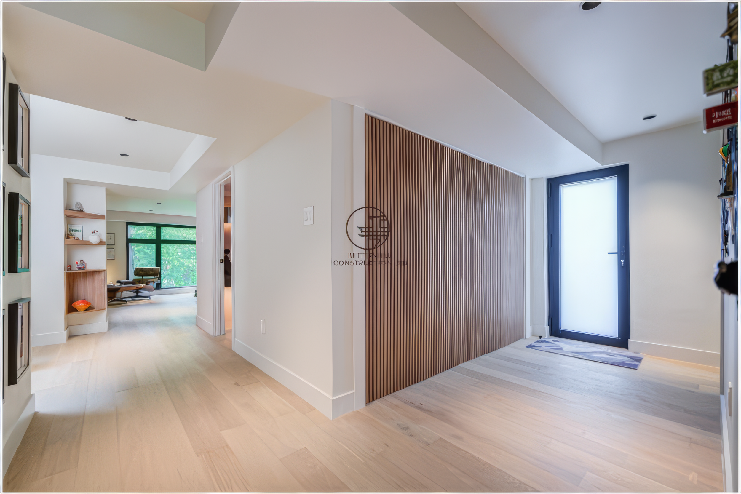modern open concept entryway renovation with wood slat accent wall and light wood flooring