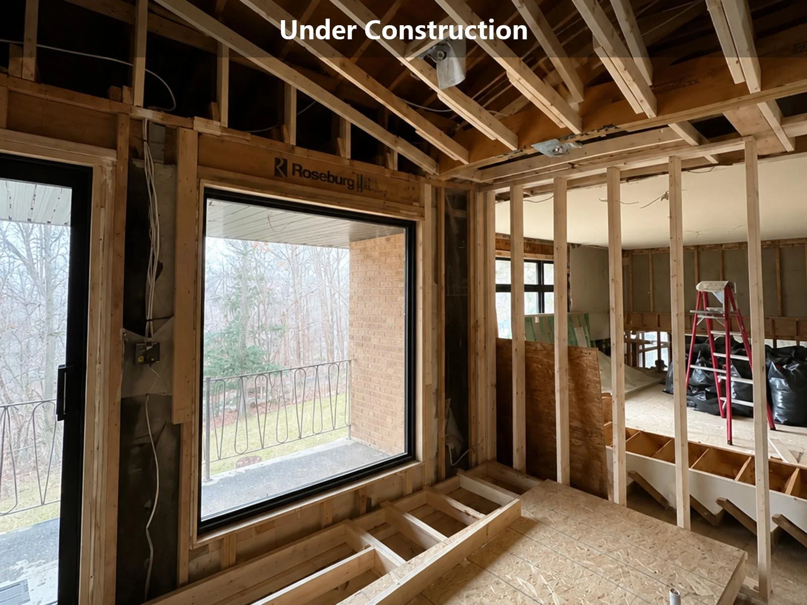 home renovation framing stage with exposed wood studs and ceiling joists