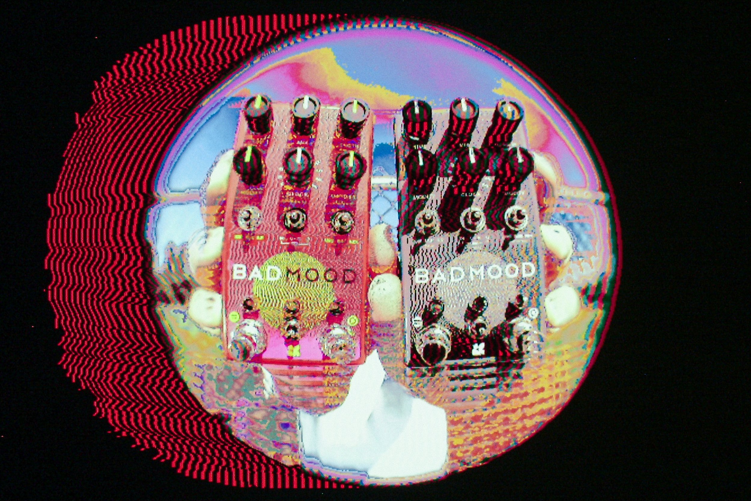 "BAD MOOD" effects pedal by Chase Bliss being held by two hands and run through a psychedelic photo filter.