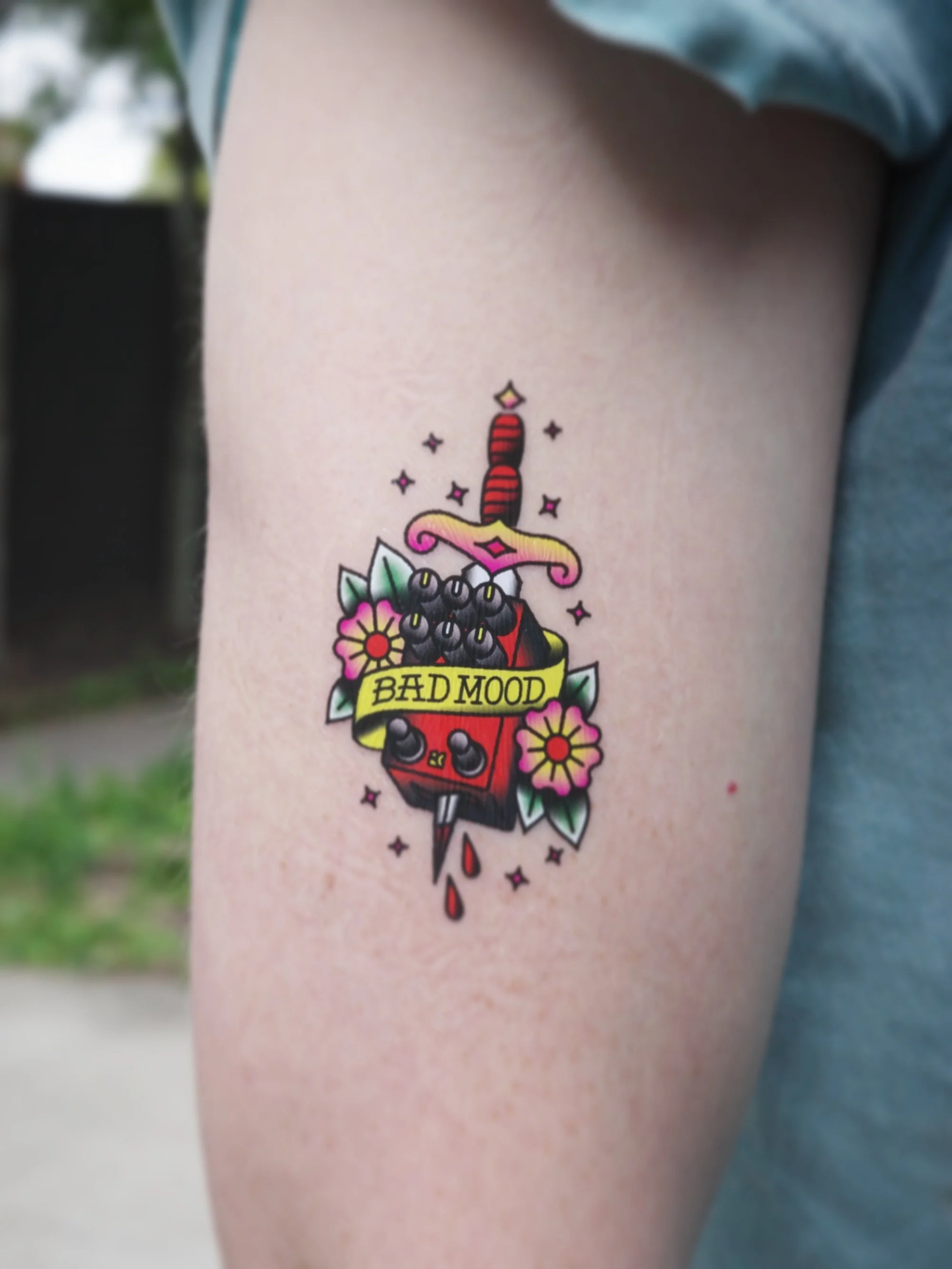 "BAD MOOD" temporary tattoo on an upper arm.