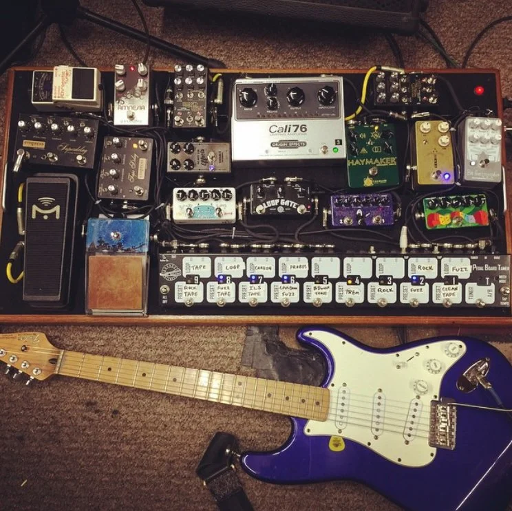Guitar and pedal board with effects pedals.