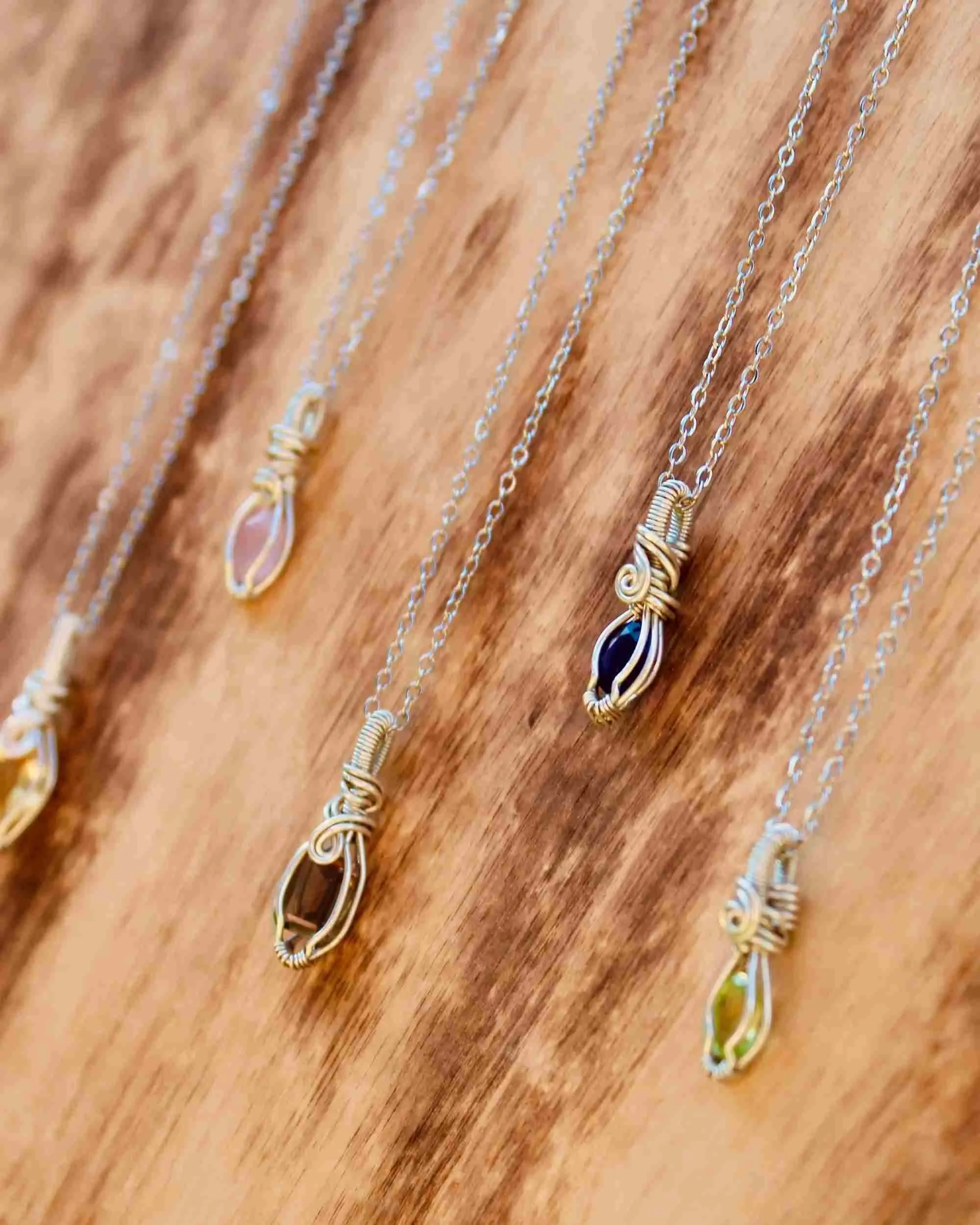 Handmade gemstone necklace displayed on a wooden surface