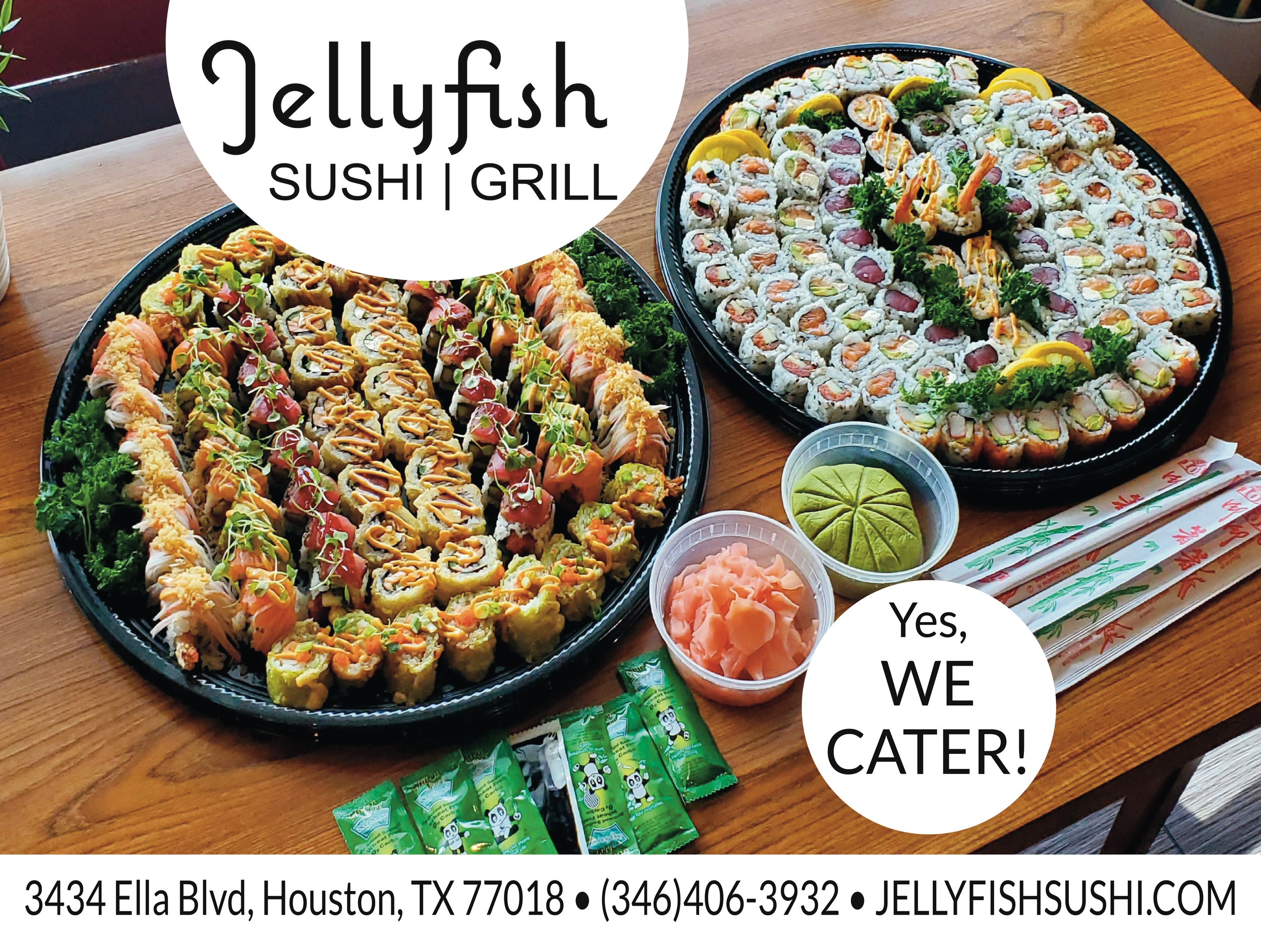 Large trays of assorted sushi rolls with various ingredients, garnished with parsley and lemon slices, along with small containers of pickled ginger and wasabi, set on a wooden table with chopsticks and fortune cookies nearby.