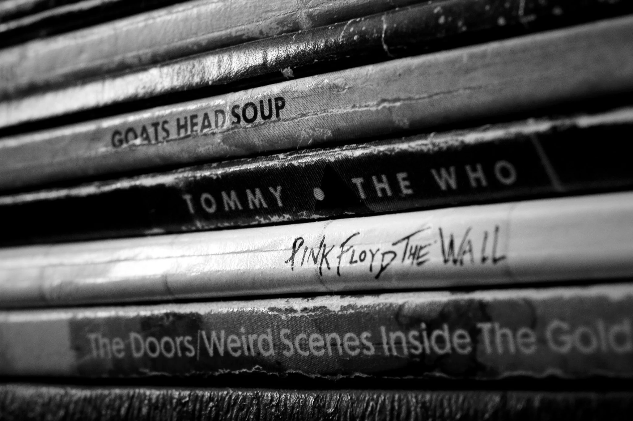 Close-up of a row of vinyl records on a shelf, with visible titles including 'GOATS HEAD SOUP' and 'Pink Floyd The Wall'.
