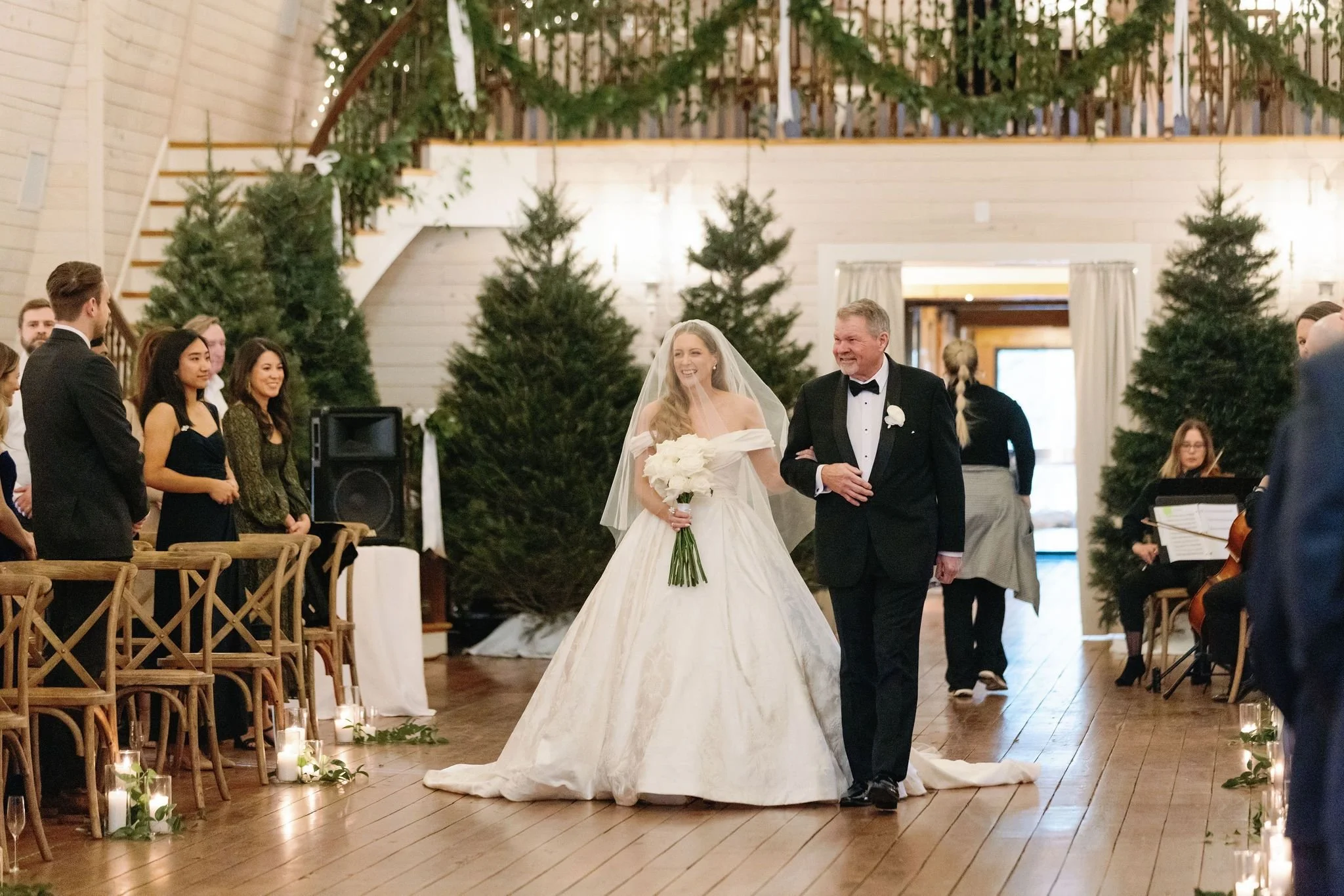 Elegant winter wedding with a grand staircase garland and evergreen trees