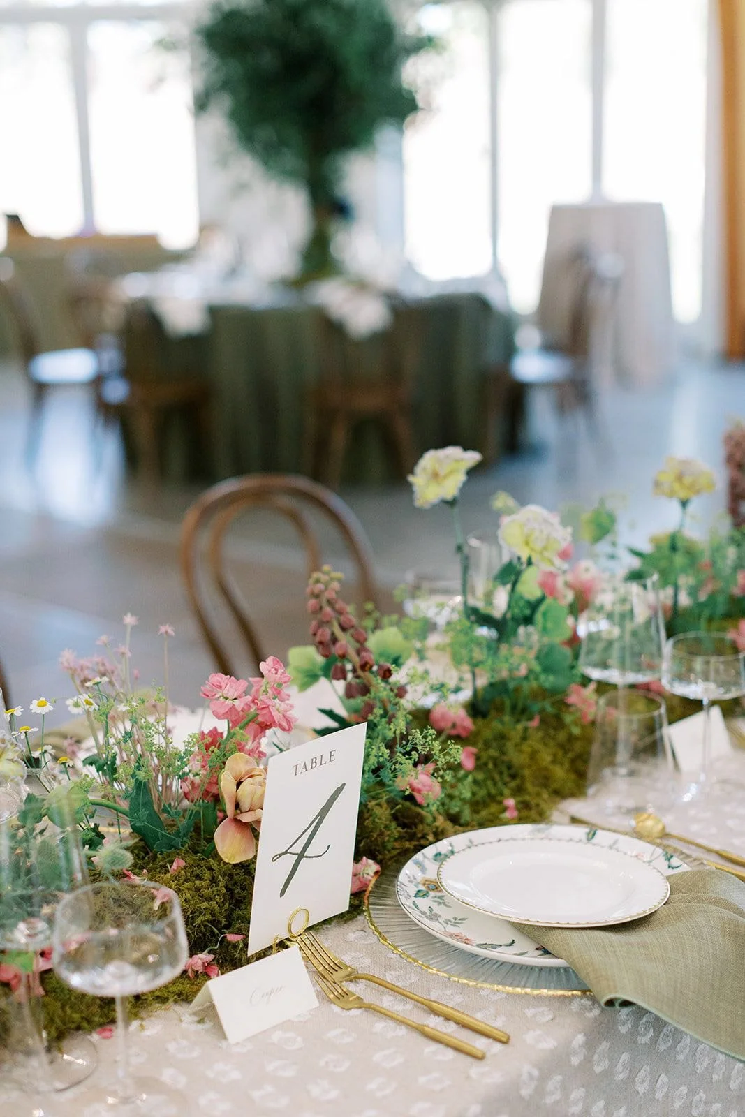 A detailed wedding table design by Wild Flora Flowers featuring moss, seasonal blooms, and soft garden florals at The Upchurch wedding venue in Raleigh, North Carolina.