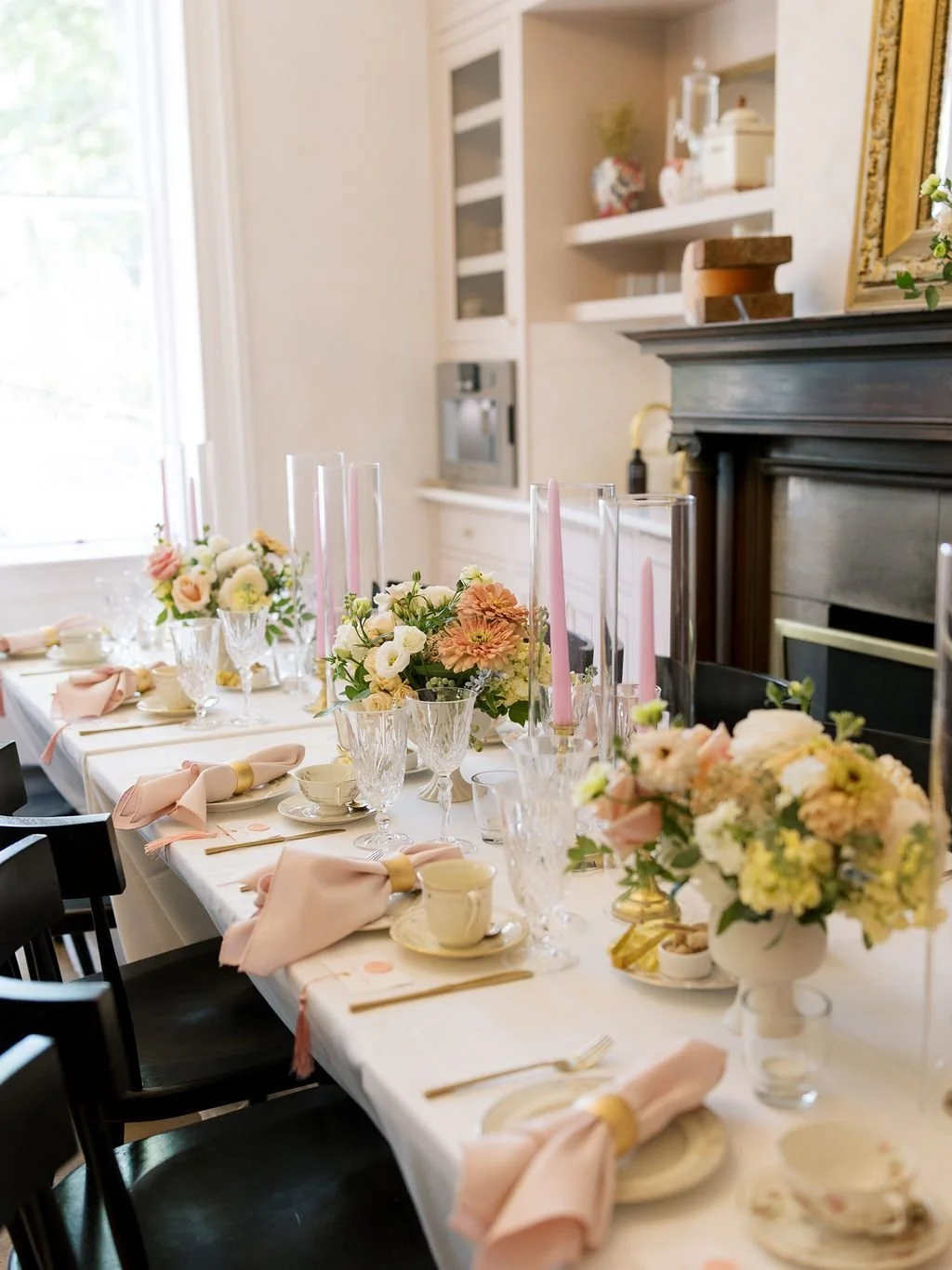 Intimate wedding dinner table with blush linens, taper candles, vintage place settings, and soft floral arrangements in a light-filled Raleigh venue