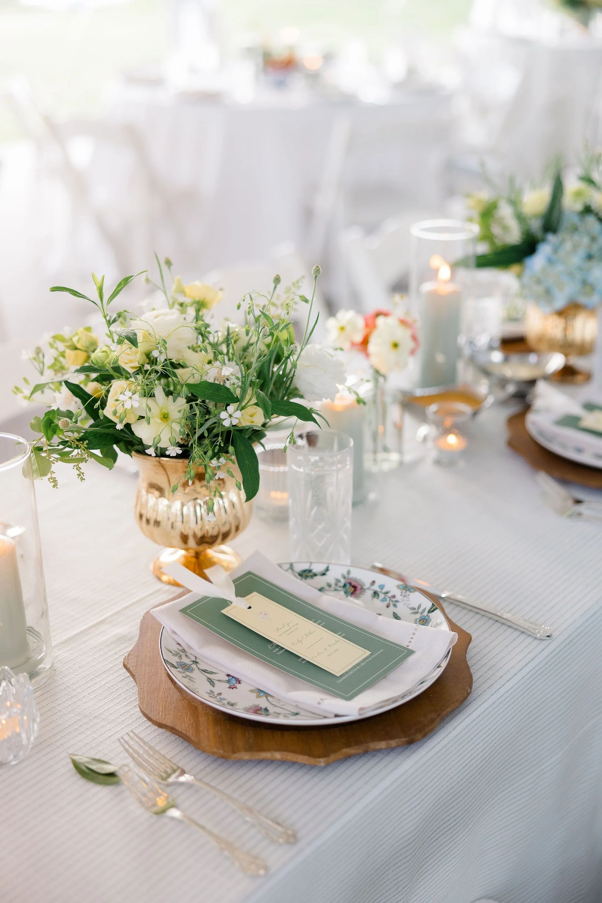 Organic flower arrangement in a tablscape setting with sage green candles and fruit