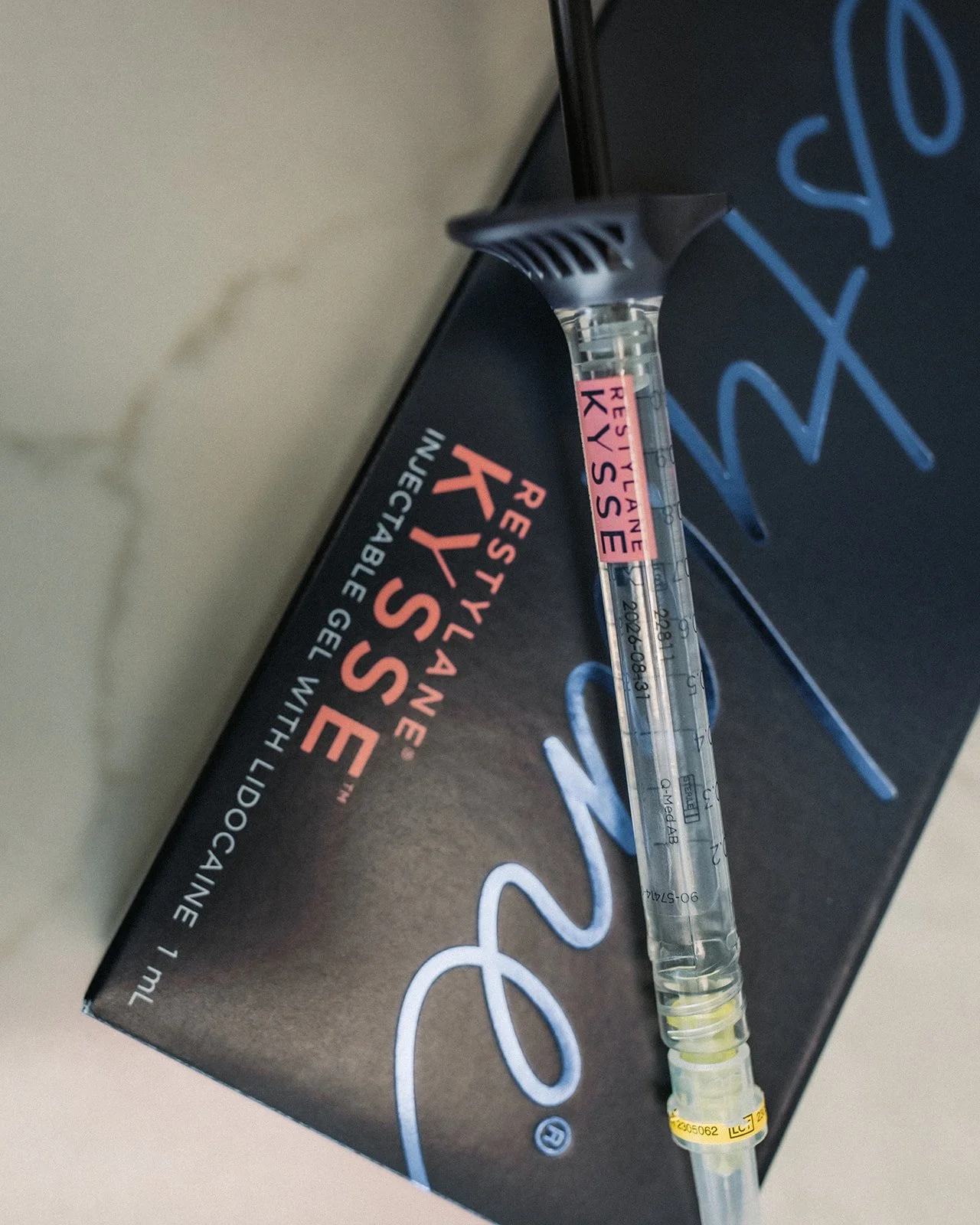 A syringe of RESTYLANE KYSSÉ ready for use in a lip filler treatment.