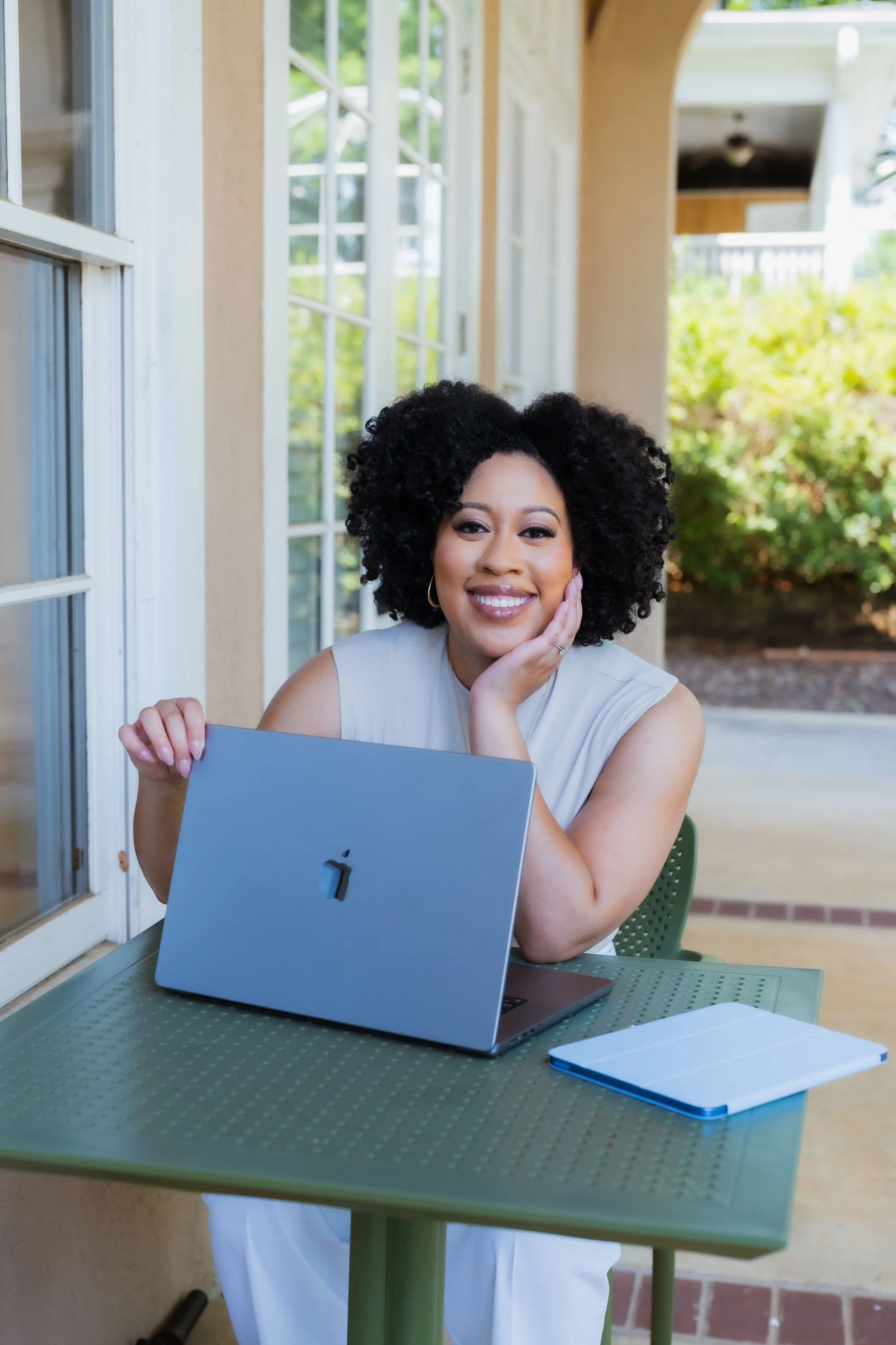 Briana Farlow Reynolds, LCSW a Black woman EMDR therapist in Atlanta, Georgia. Holding a laptop and smiling.
