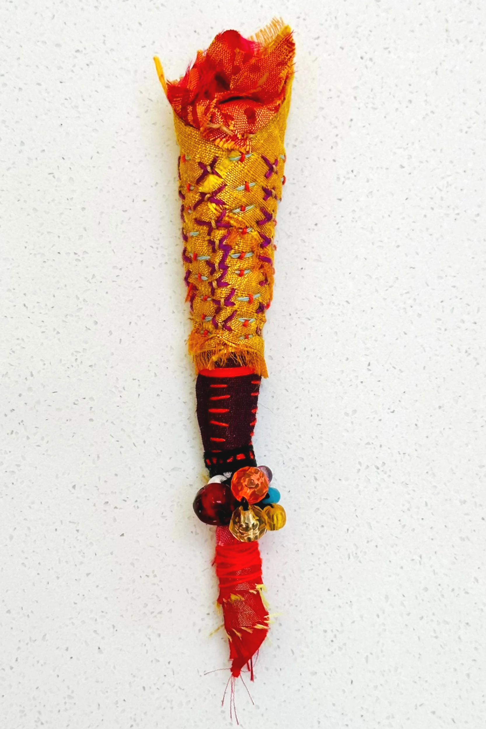 Flame Memory   (2025)   felt, upcycled fabric, beads, Sashiko thread, embroidery thread   5.5" x 1.5" x 1.5"  