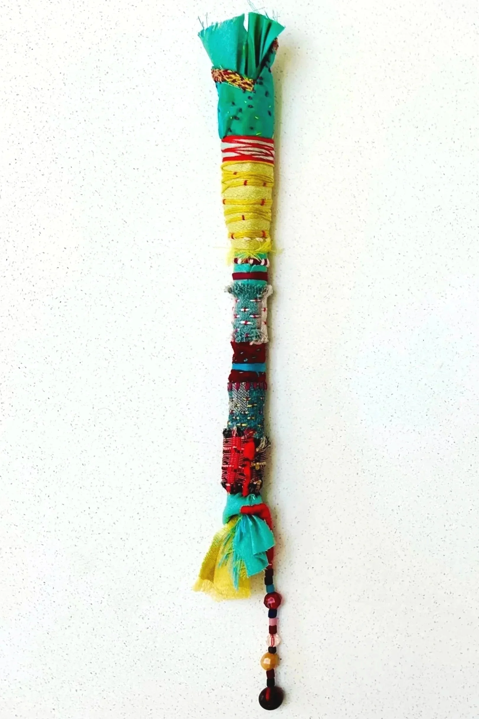 Close Consideration   (2025)   felt, upcycled fabric, beads, Sashiko thread, embroidery thread   12" x 1.5" x 1.5"   