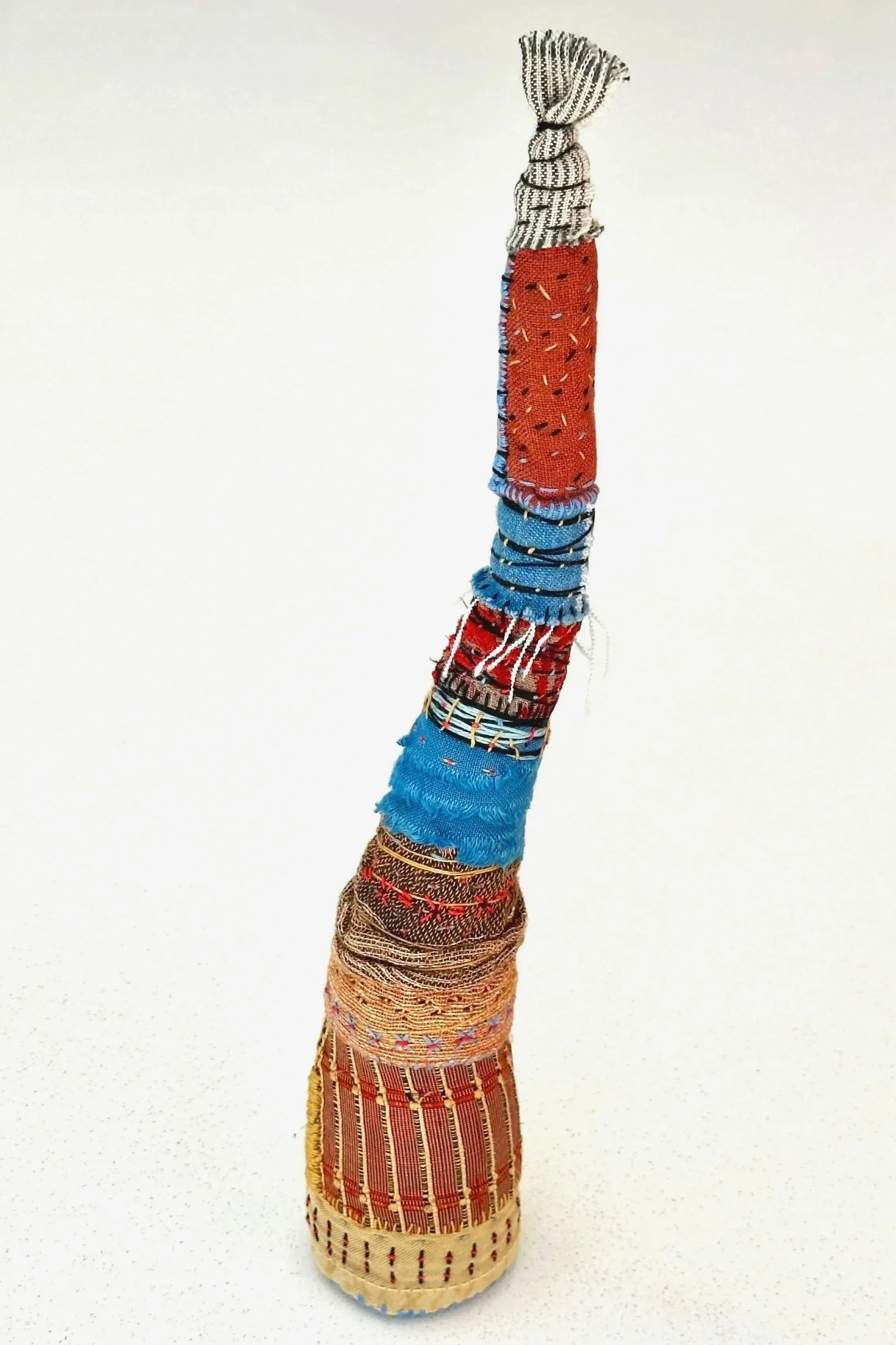 Torched   (2025)   (freestanding)   felt, upcycled fabric, Sashiko thread, embroidery thread   13" x 2.5" x 2.5"   