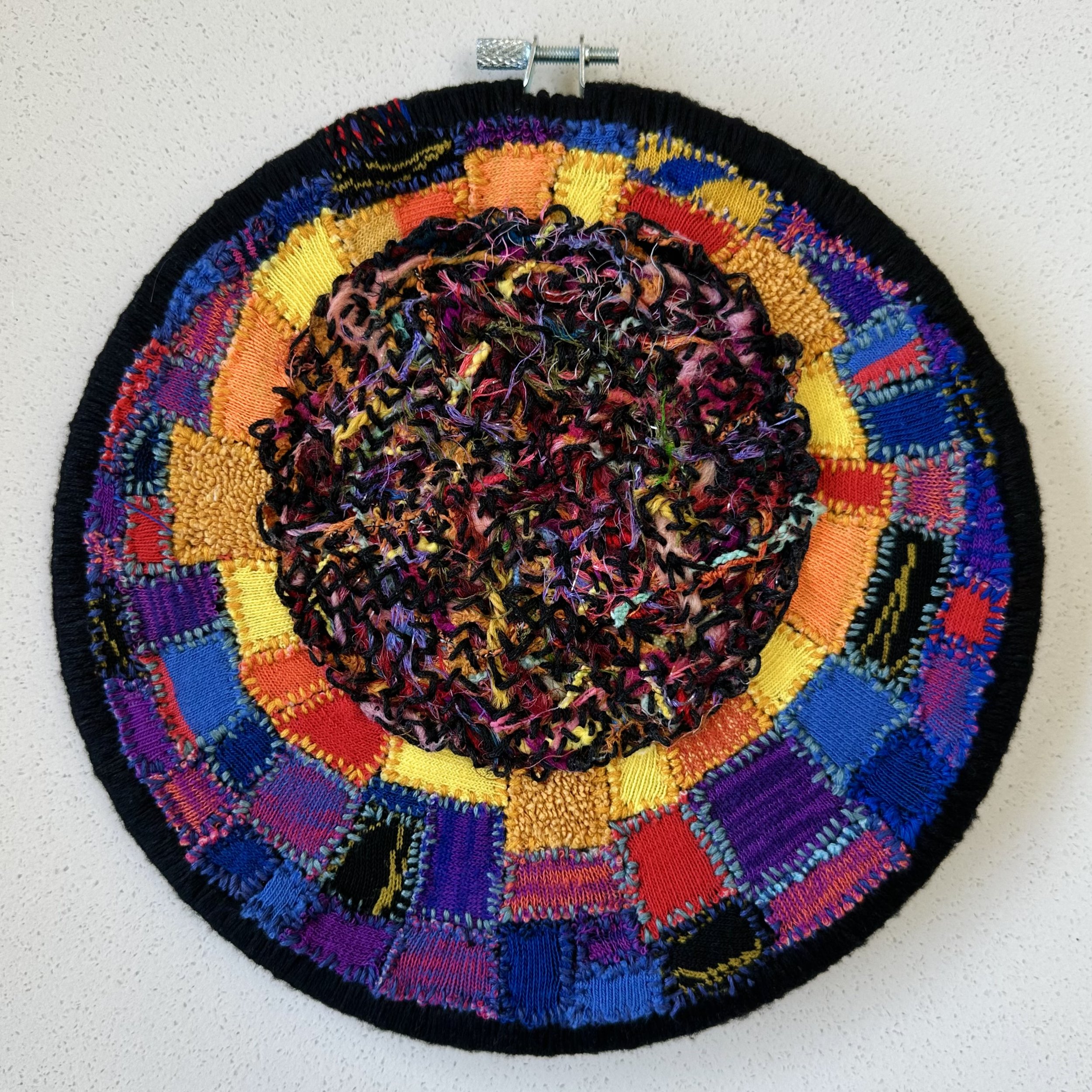 Moral Eclipse (2023) embroidery thread on old socks and leggings 8.5" disc $
