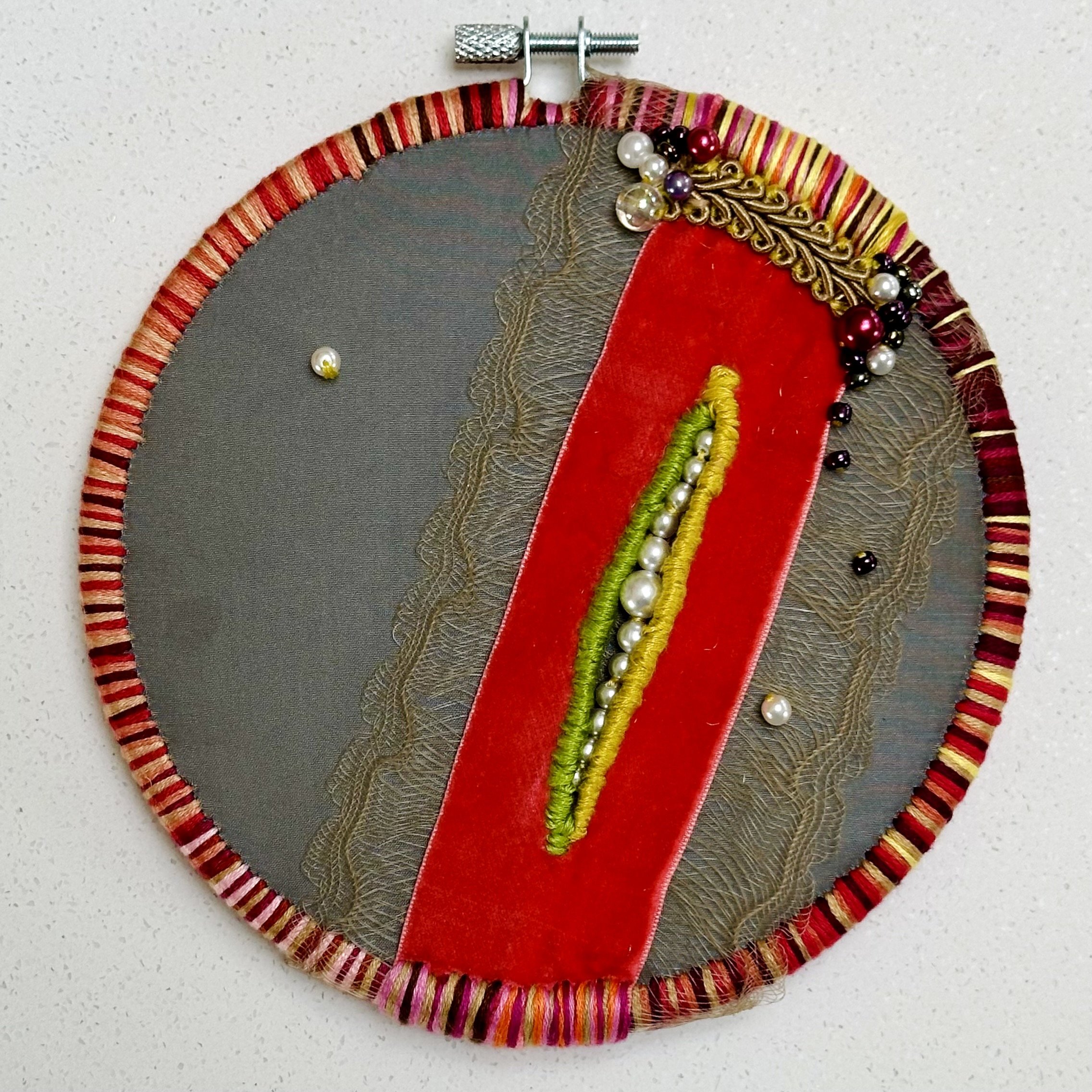 Seeds 1 (upper half) (2024) fabric, velvet ribbon, trim, beads, embroidery thread, and yarn with beads 6.5" disc $