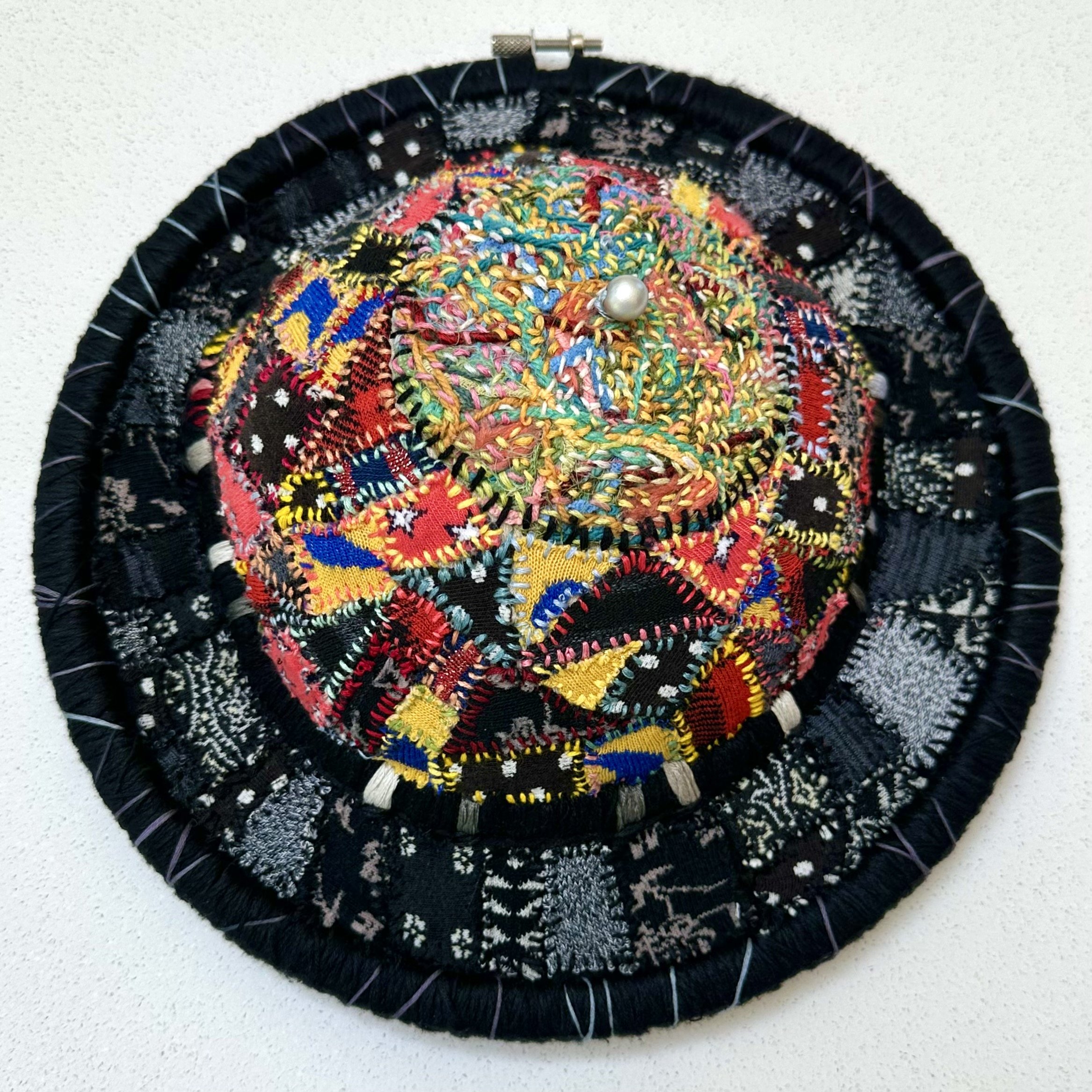 Ensemble: Reconfigured Self (2023) embroidery thread on old shirts and socks, 1/2 bra, stuffing, and a silver bead from a cocktail toothpick 11.5" x 4" $