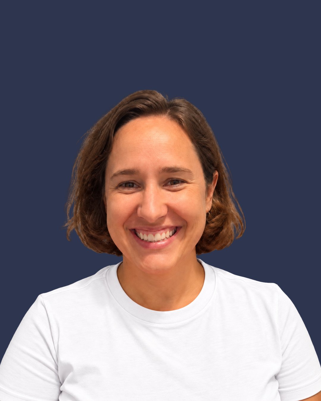 Kate Boersen smiling with a white shirt against a dark background.