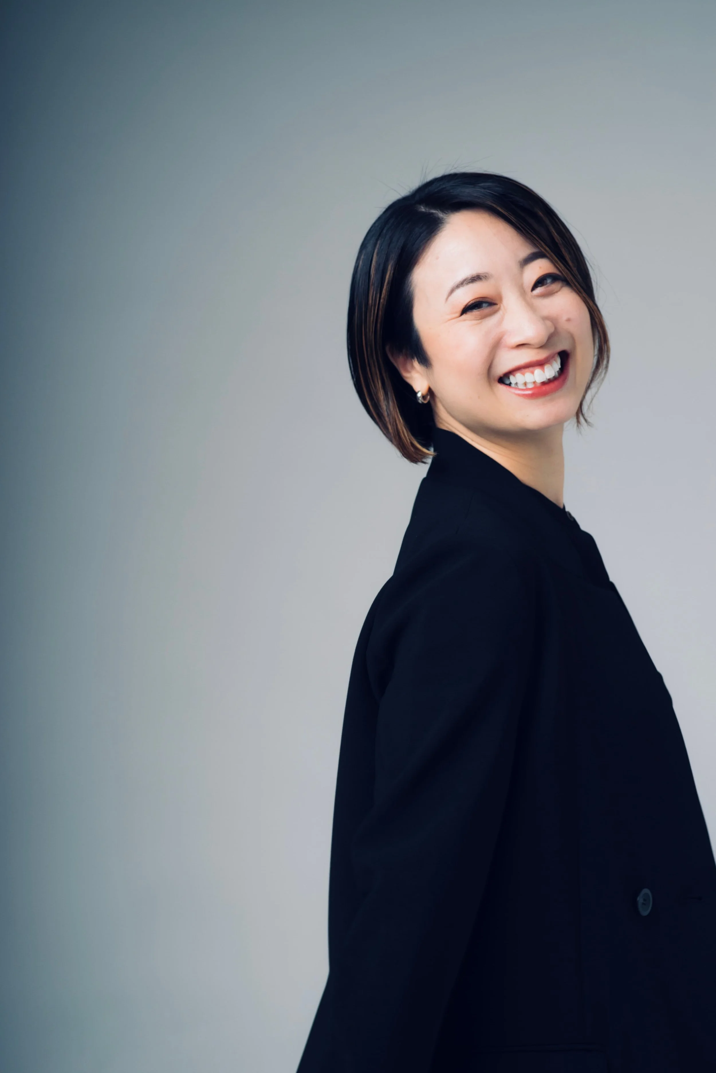 笑顔の若い女性が黒いジャケットを着ている