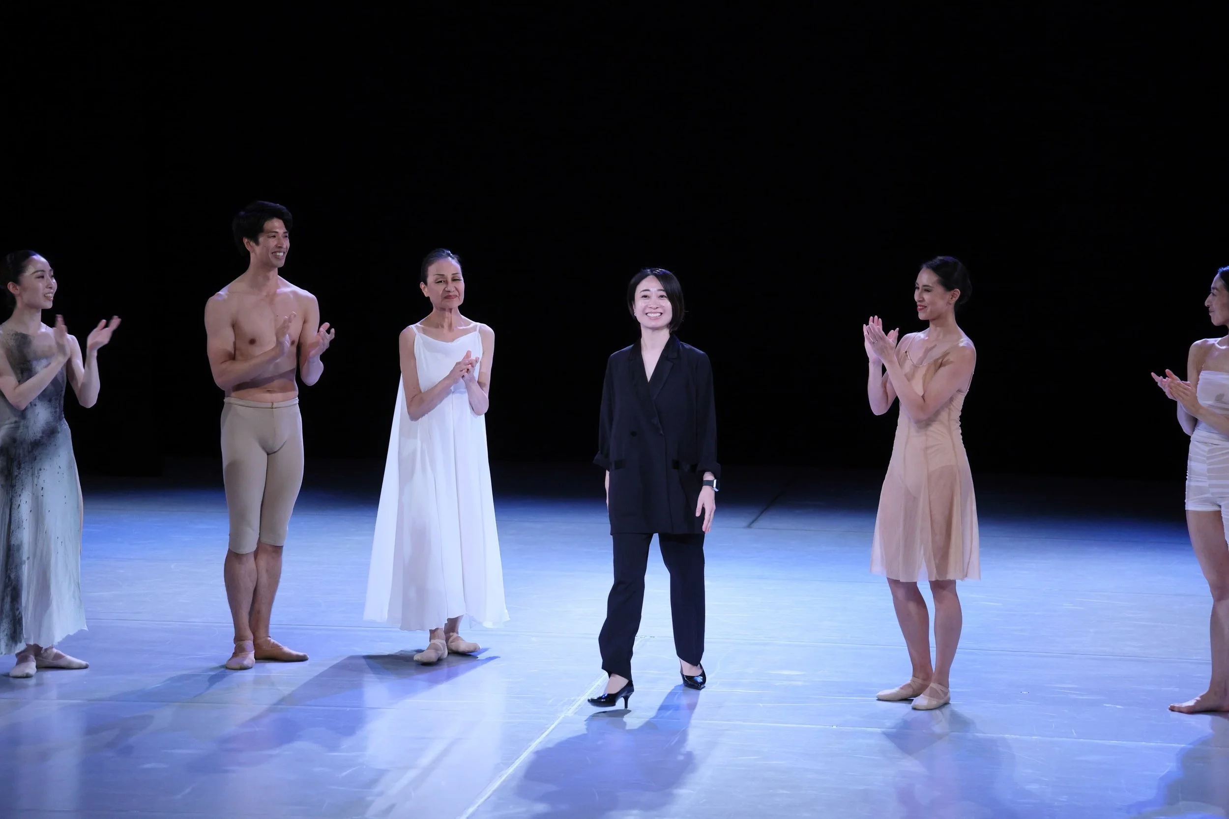 舞台に立つバレエダンサーと女性の振付師