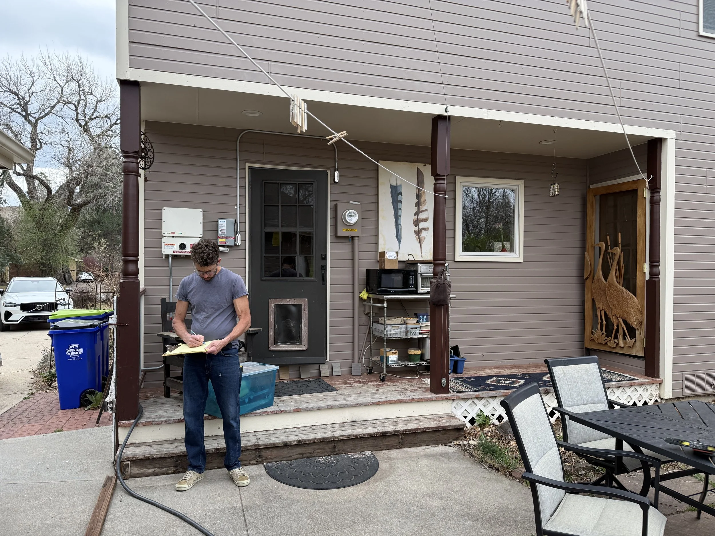 Builder looks over plans with homeowner's dog in hand
