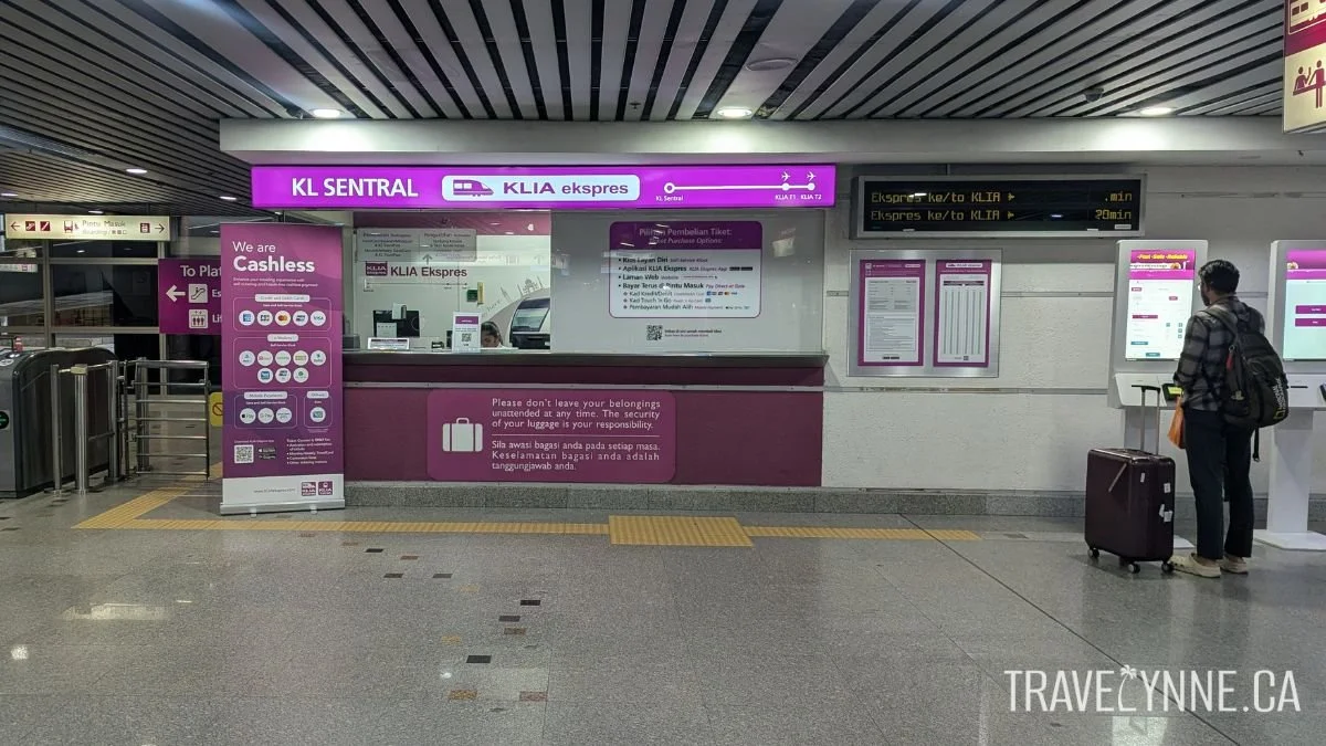 A pink KLIA ekspres booth in KL Sentral Station, Kuala Lumppur, with instructions to purchase tickets for the airport train
