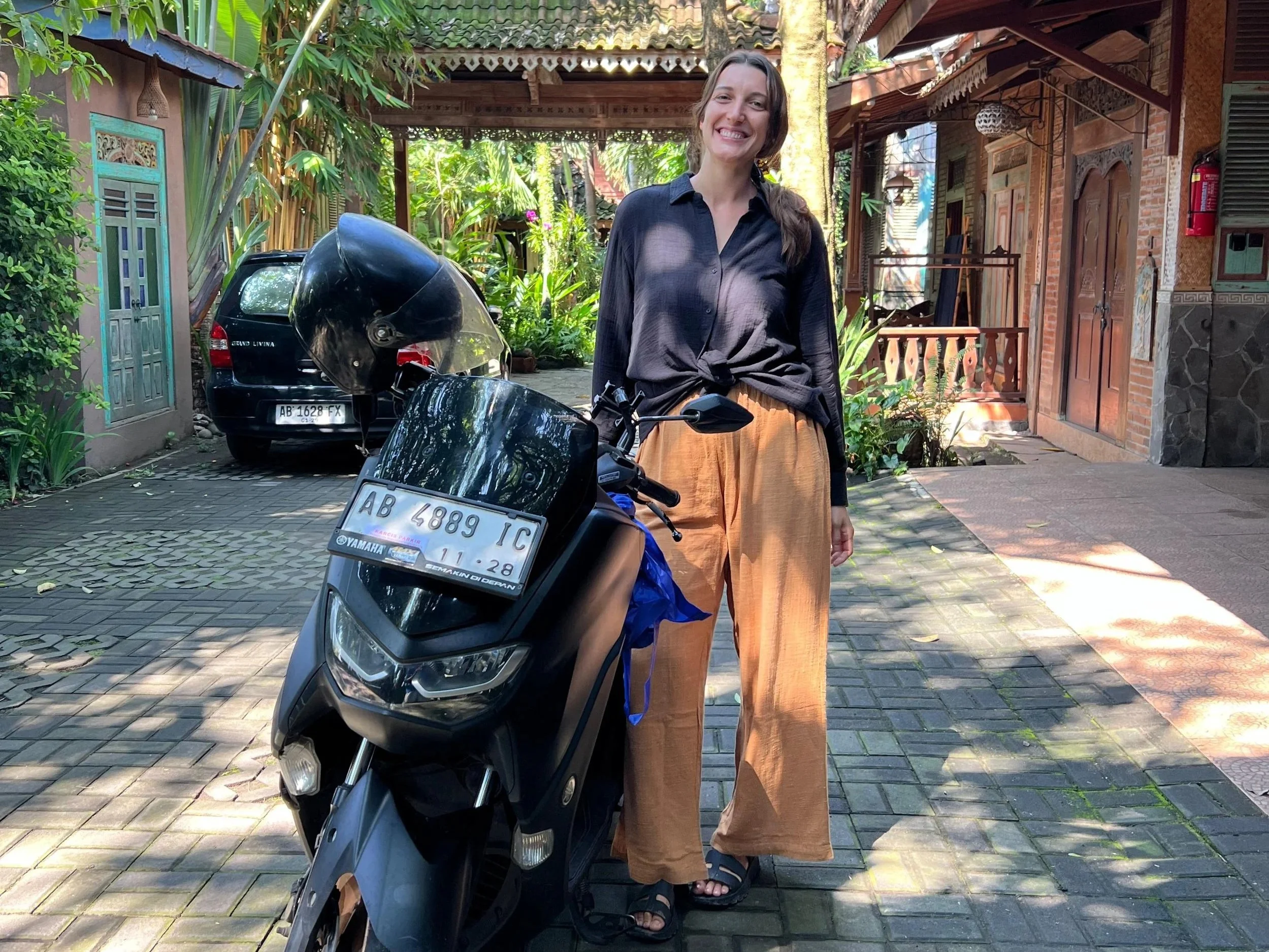 Lynne stands next to her rental bike, a Yamaha NMAX, at her hotel in Yogyakarta