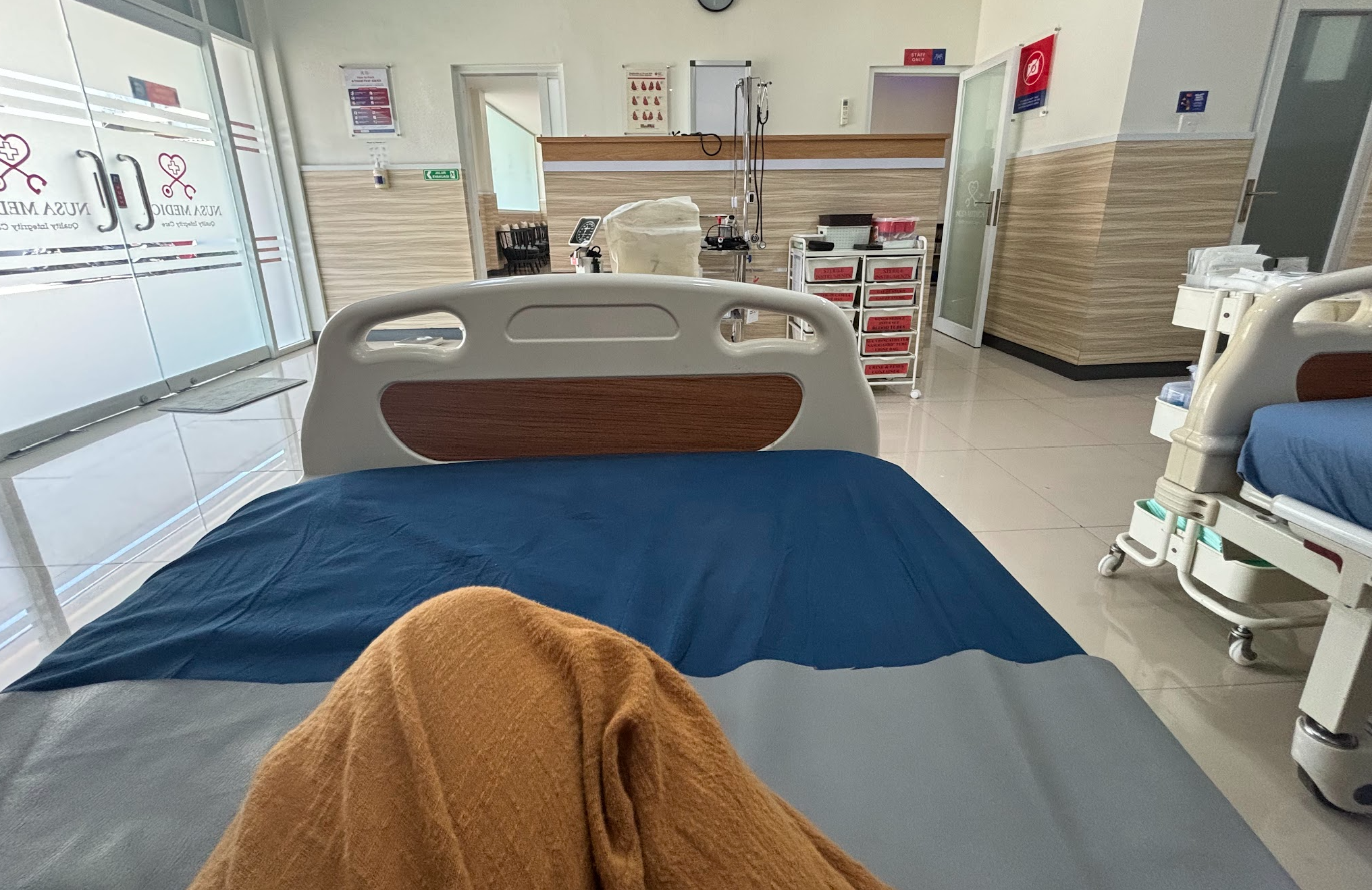 A woman's leg is seen sitting on a hospital bed in a n empty clinic called Nusa Medical in Bali.