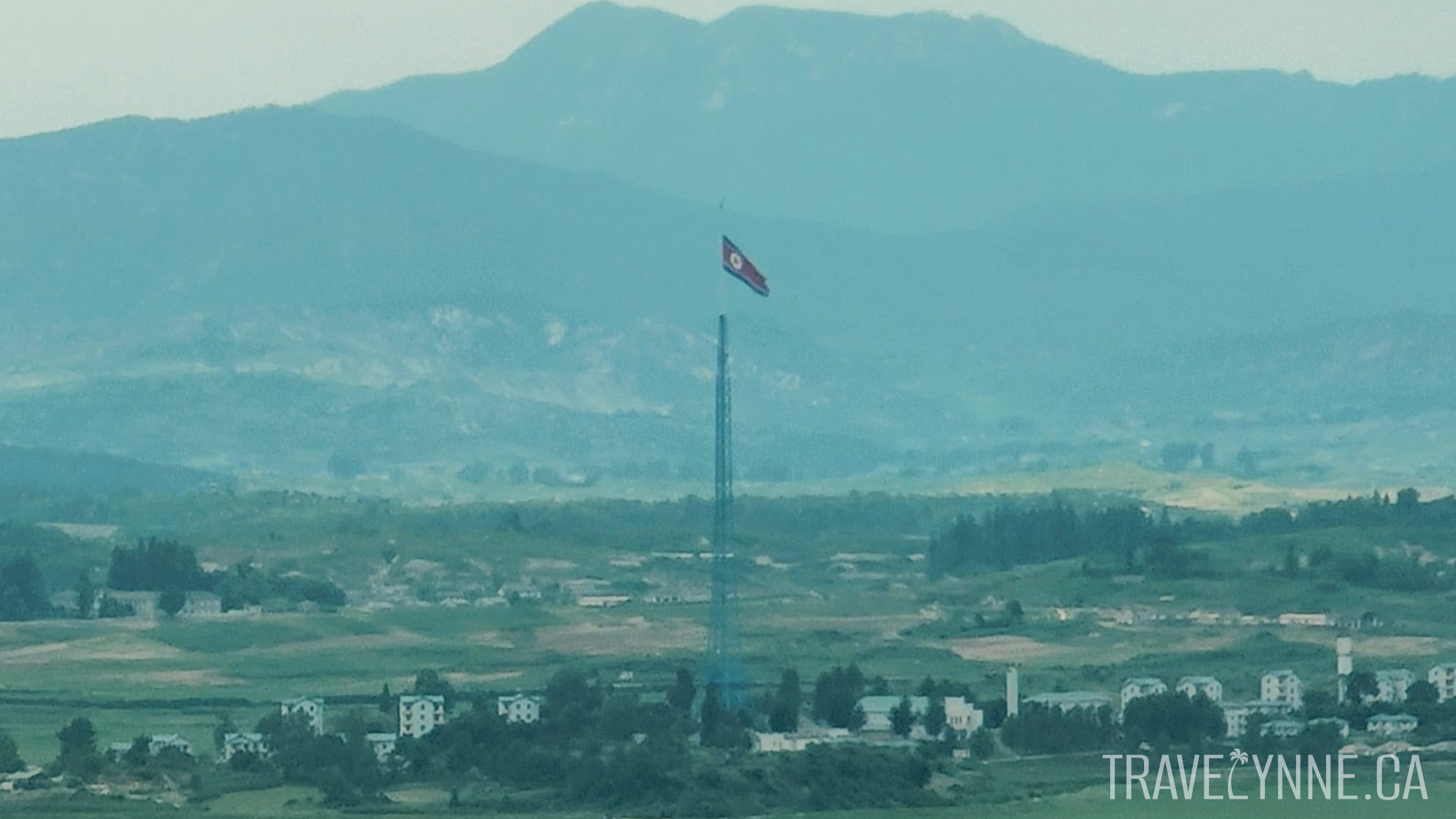 A 160 metre tall North Korean flag pole photographed from binoculars at the Dora Observatory in the DMZ.