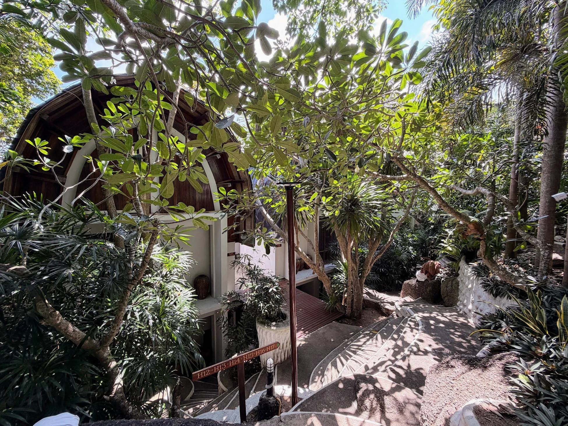 In a forest garden in Koh Tao, hotel rooms peek out from behind trees, with hills and steps needed to reach each one.