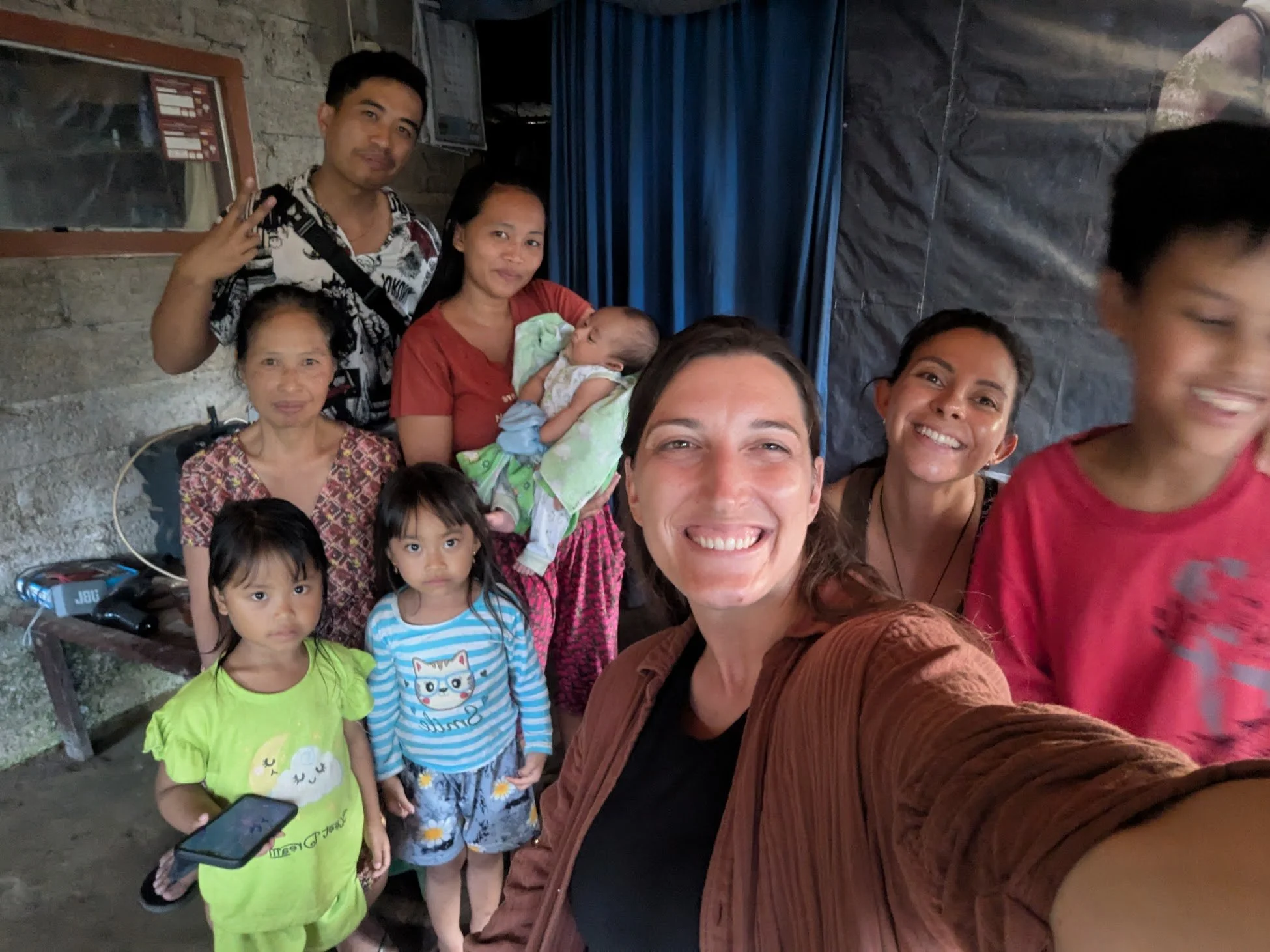 Lynne takes a selfie with a family in Munduk, Bali, parents with a new baby two young children and grandmother