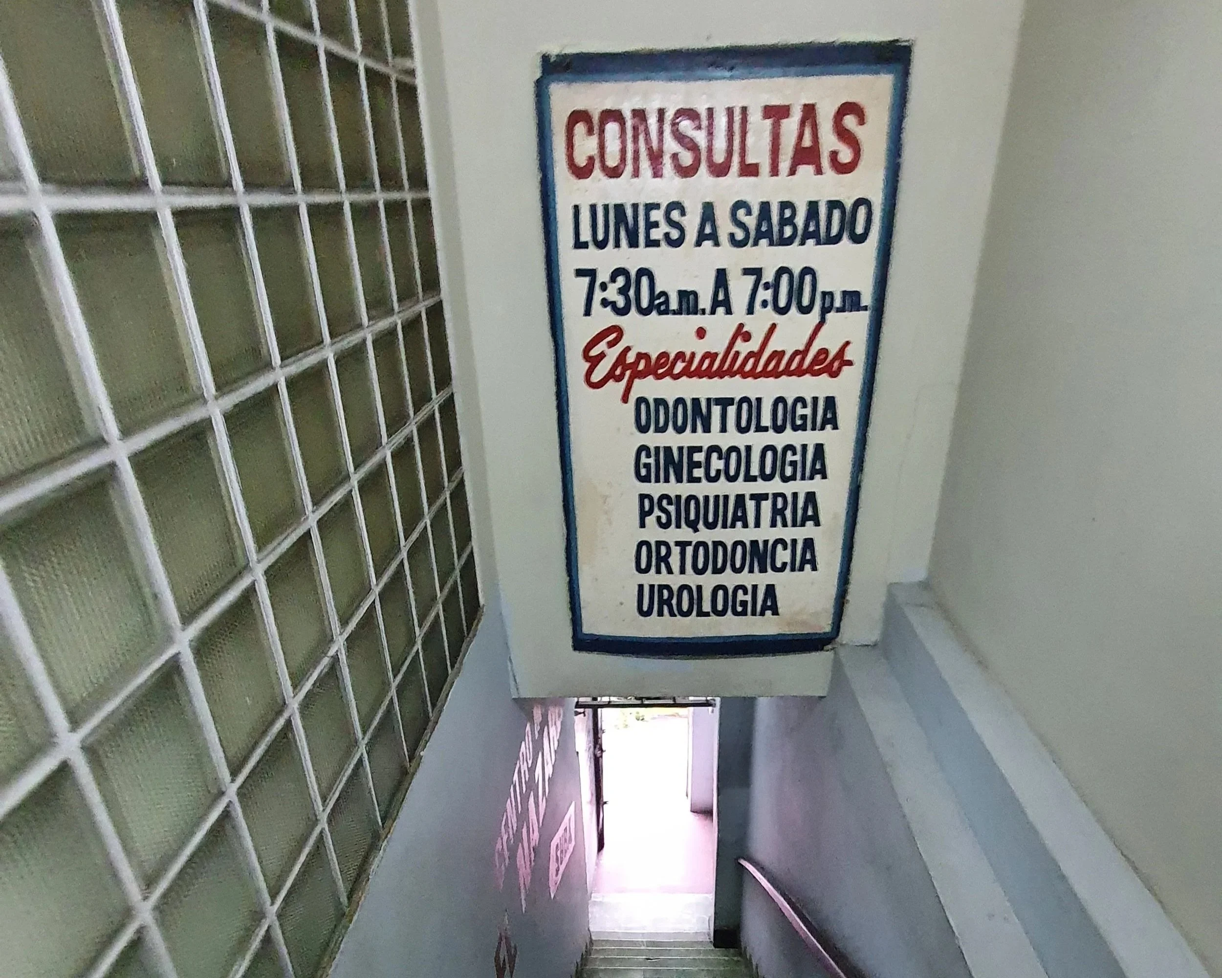 a sign at a health clinic in Panama City reads Consultas Lunes a Sabado with specialists in Odontologia, Ginecologia, Psiquiatria, and more