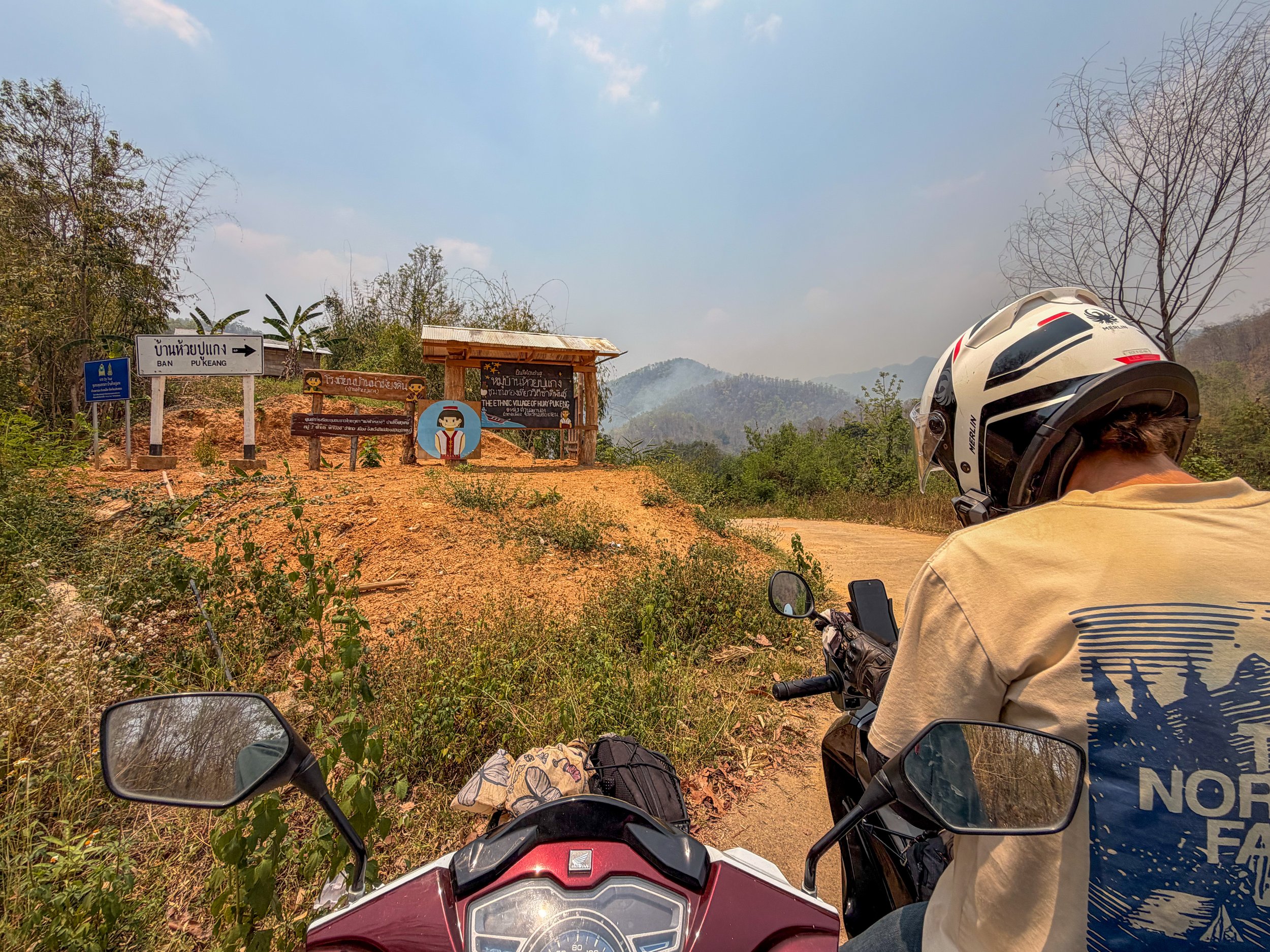 POV from a scooter with a driver ahead of her checking maps on his phone, at Huey Pukeng long neck village in northern Thailand on the Mae Hong Son loop
