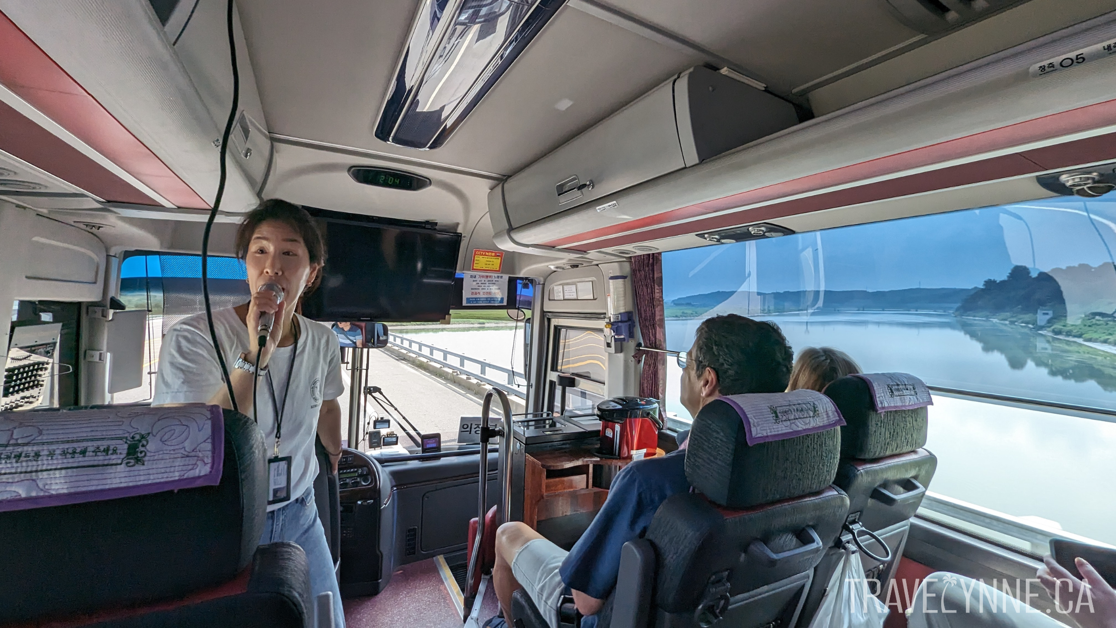 Our South Korean tour guide, Jenny, speaks into a microphone as we drive out of the DMZ in our tour bus.