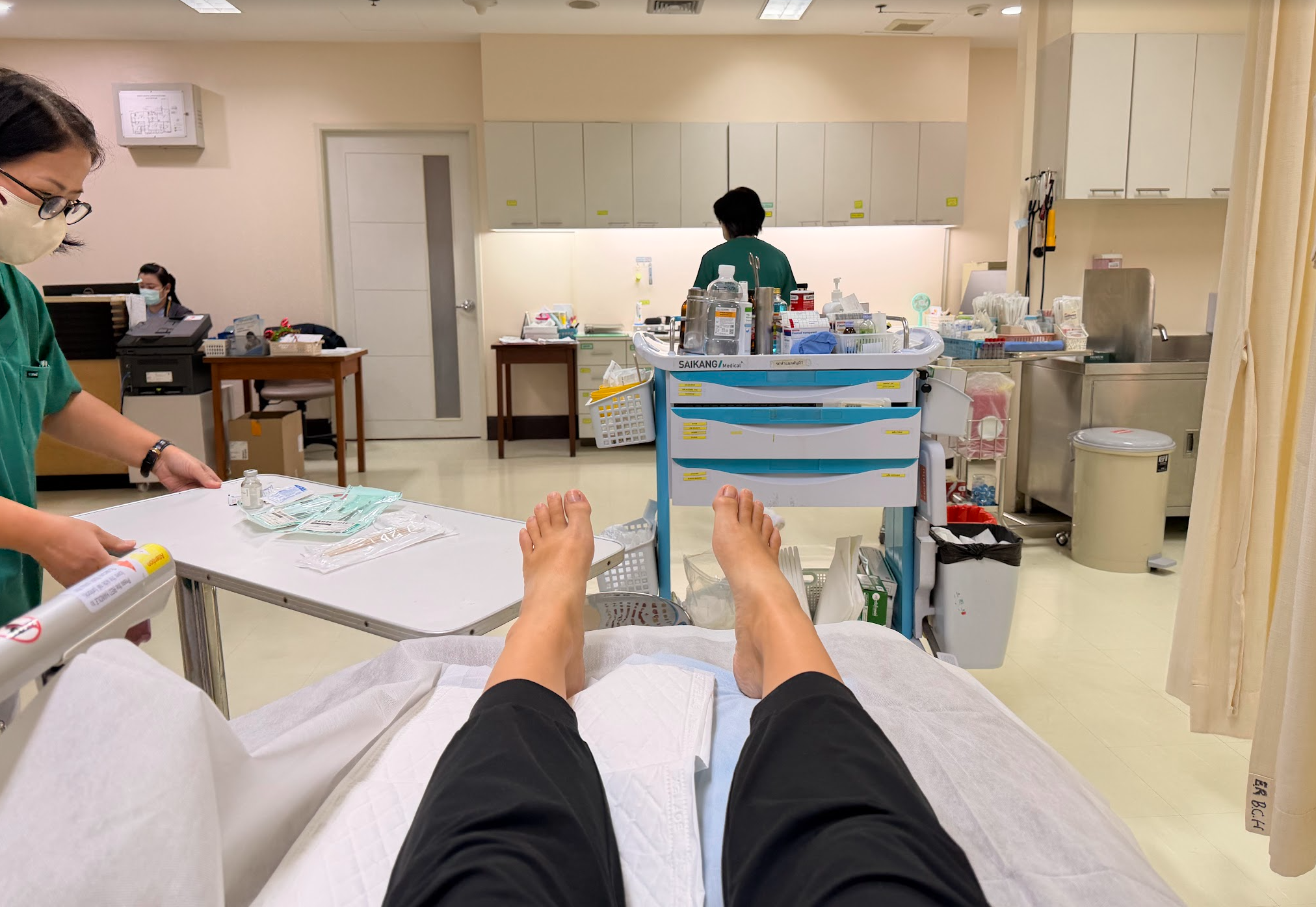 From the patient's POV, you see her feet and a nurse preparing for a small toenail operation in a hospital setting