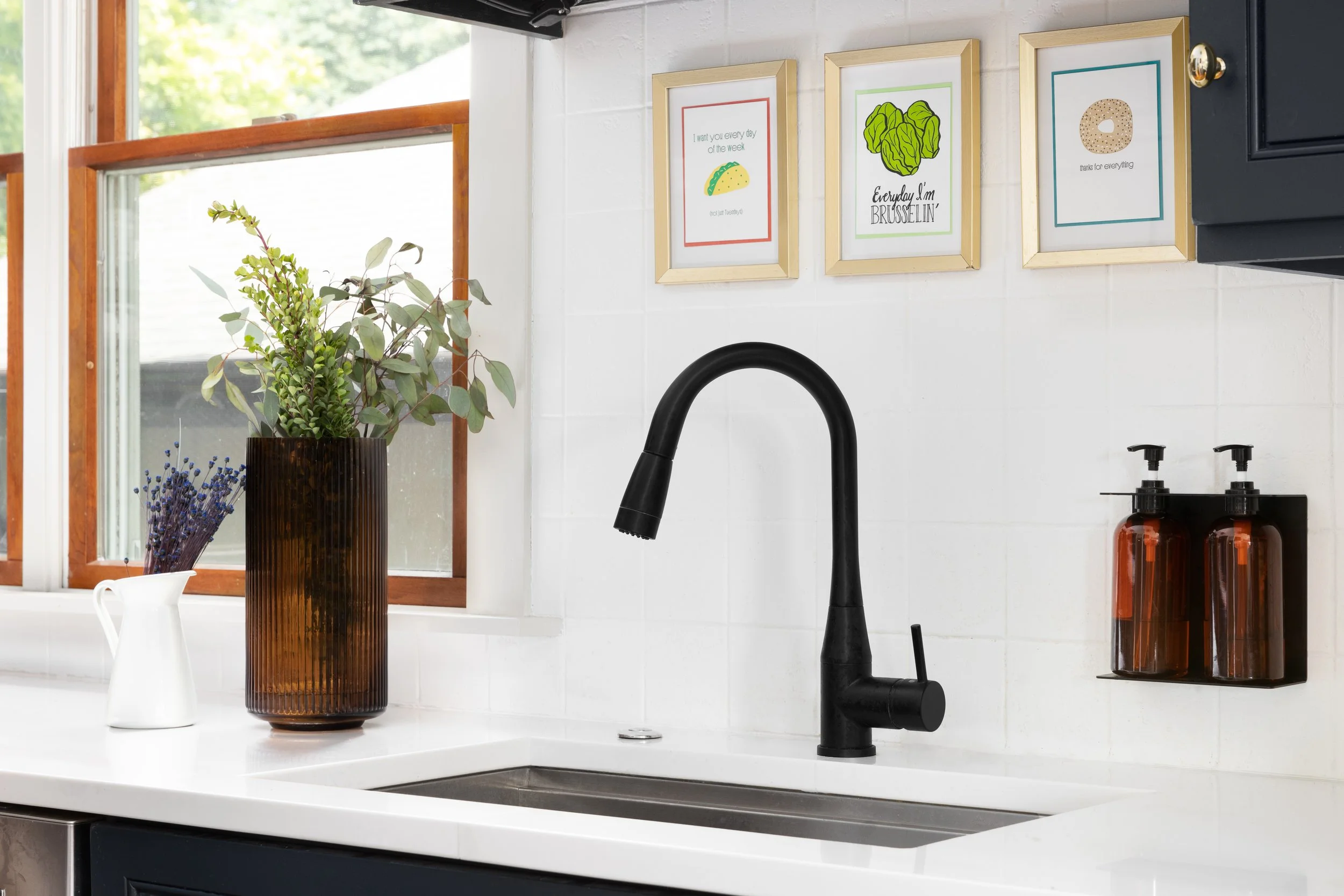 Kitchen detail white backsplash black faucet fun artwork