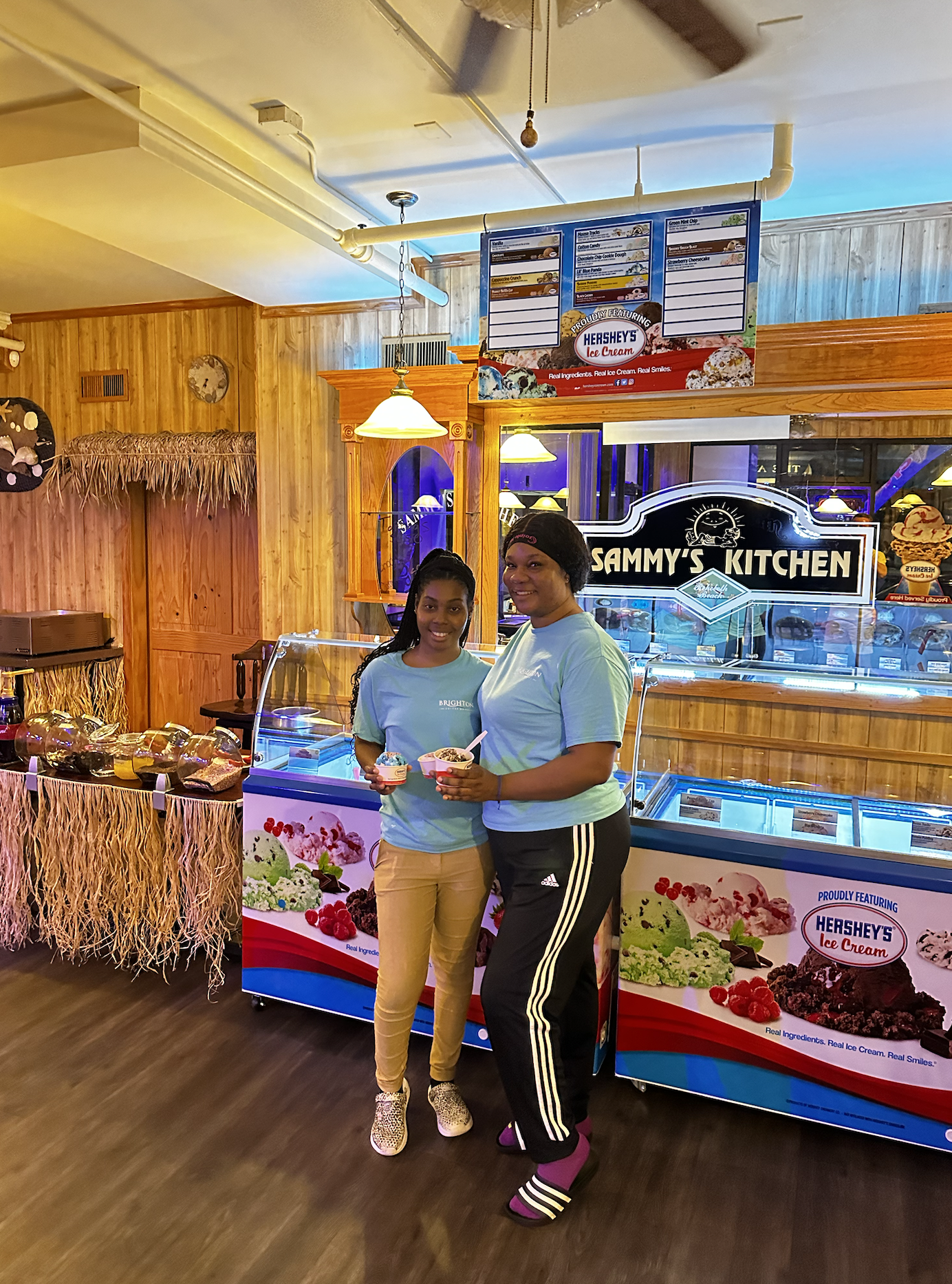  Our friends at the Brighton Suites getting free ice cream on opening day. Standing in front of a beachy wall. standing in a very beachy room.  The room is very cozy.  