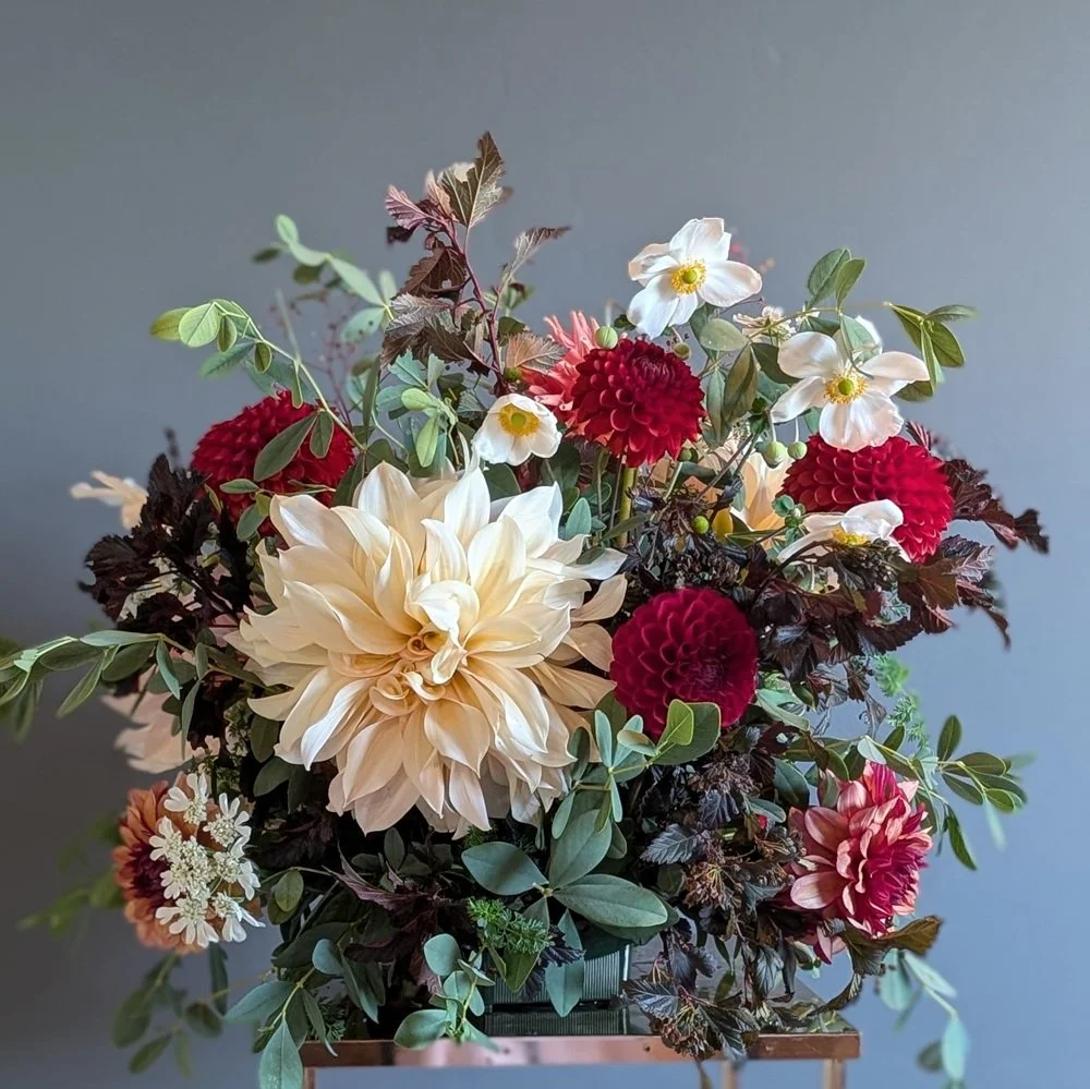Fall color large podium arrangement highlighting reds, oranges and cream