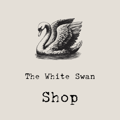 A black and white illustration of a white swan with outstretched wings, paired with the text 'The White Swan Shop' in a distressed font. promoting www.thewhiteswan.net