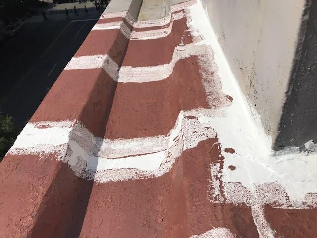 Close-up of a rooftop with red and white painted patterns on the concrete surface.