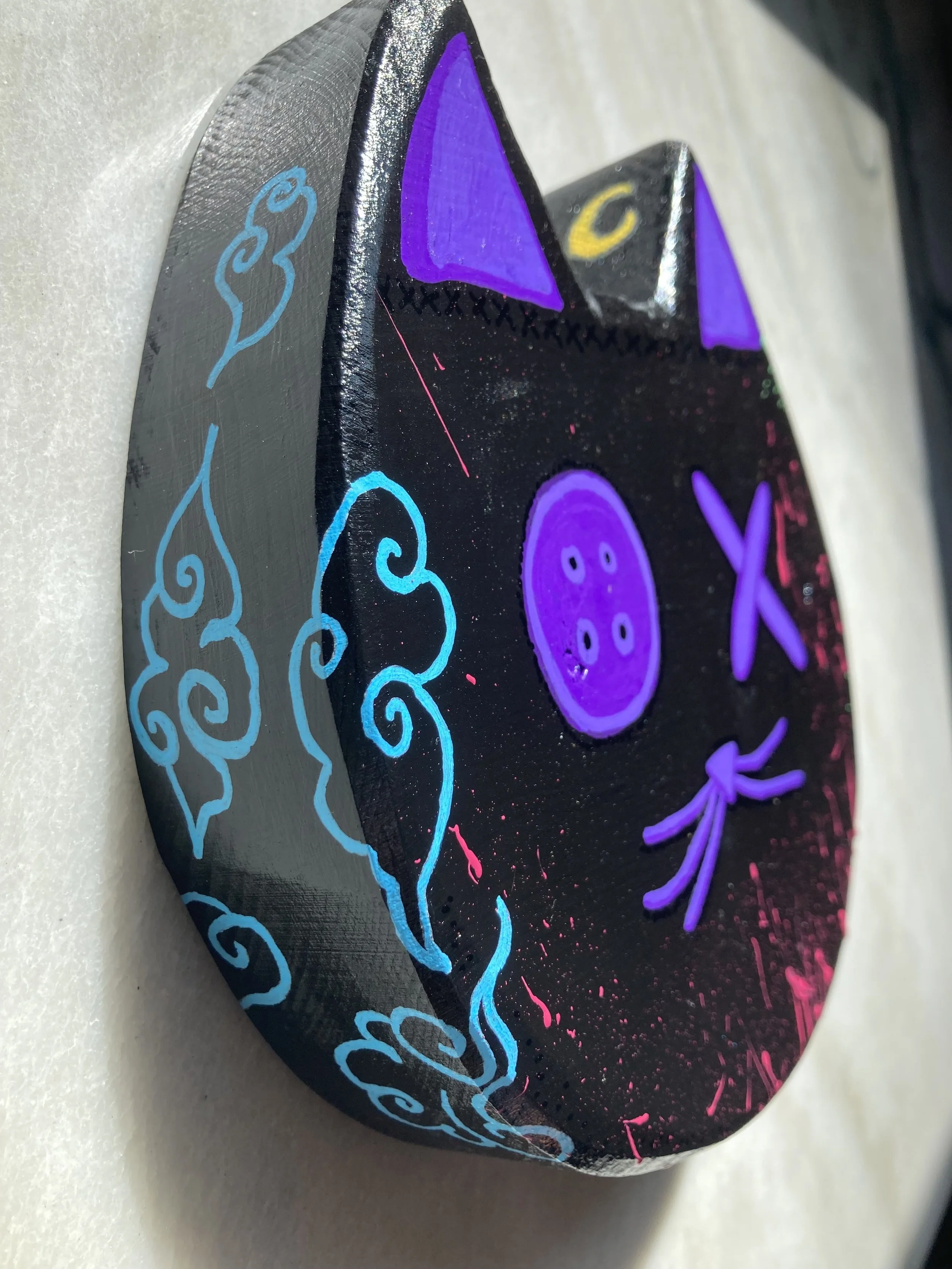 Painted wood cat head, focused on blue cloud detail