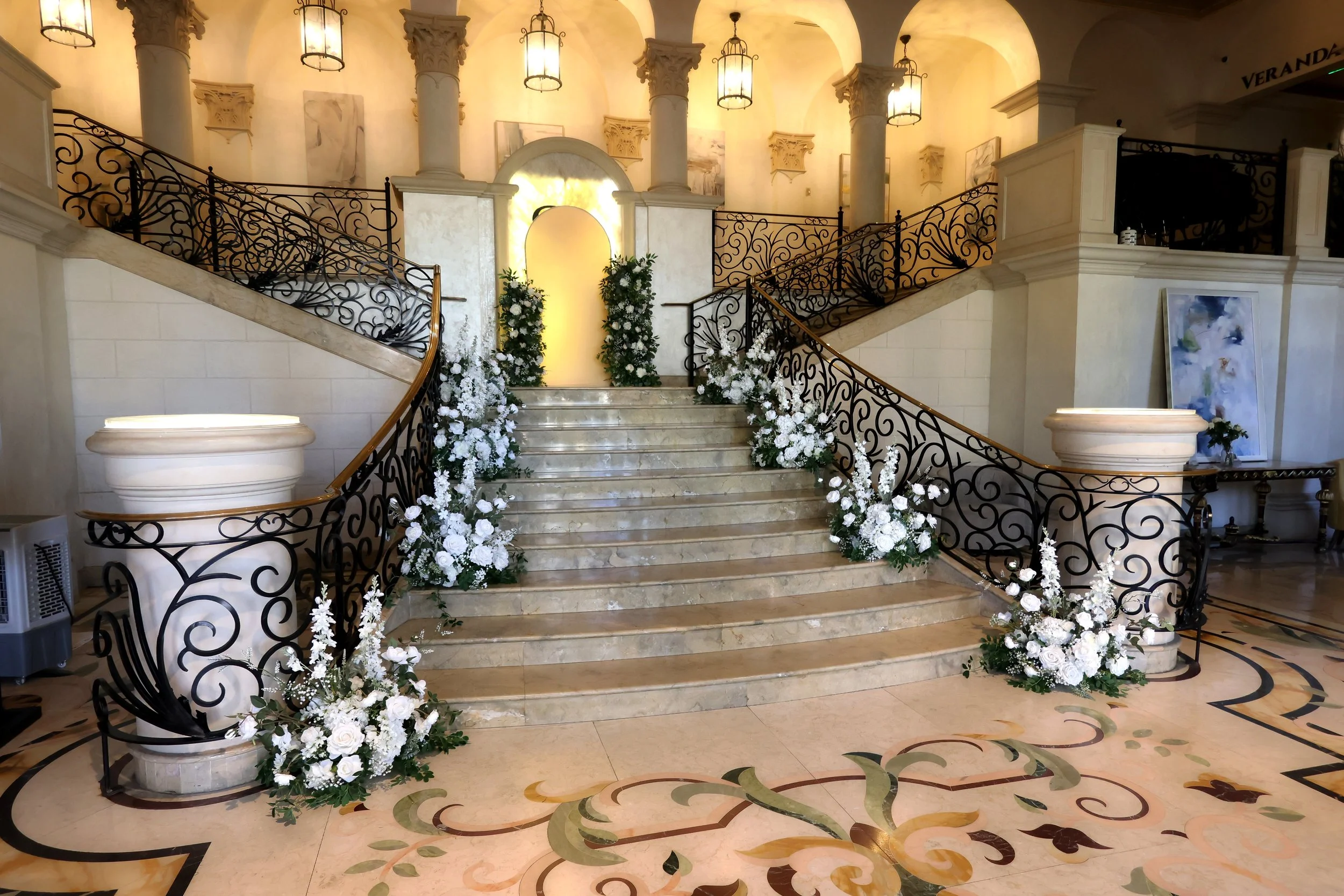 Large marble staircase with floral arrangements lining the steps