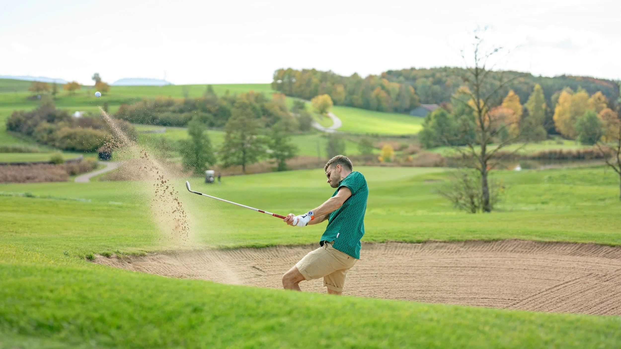 Athlete hitting a golf shot from a bunker, illustrating how performance anxiety can affect focus, automaticity, and execution in sports